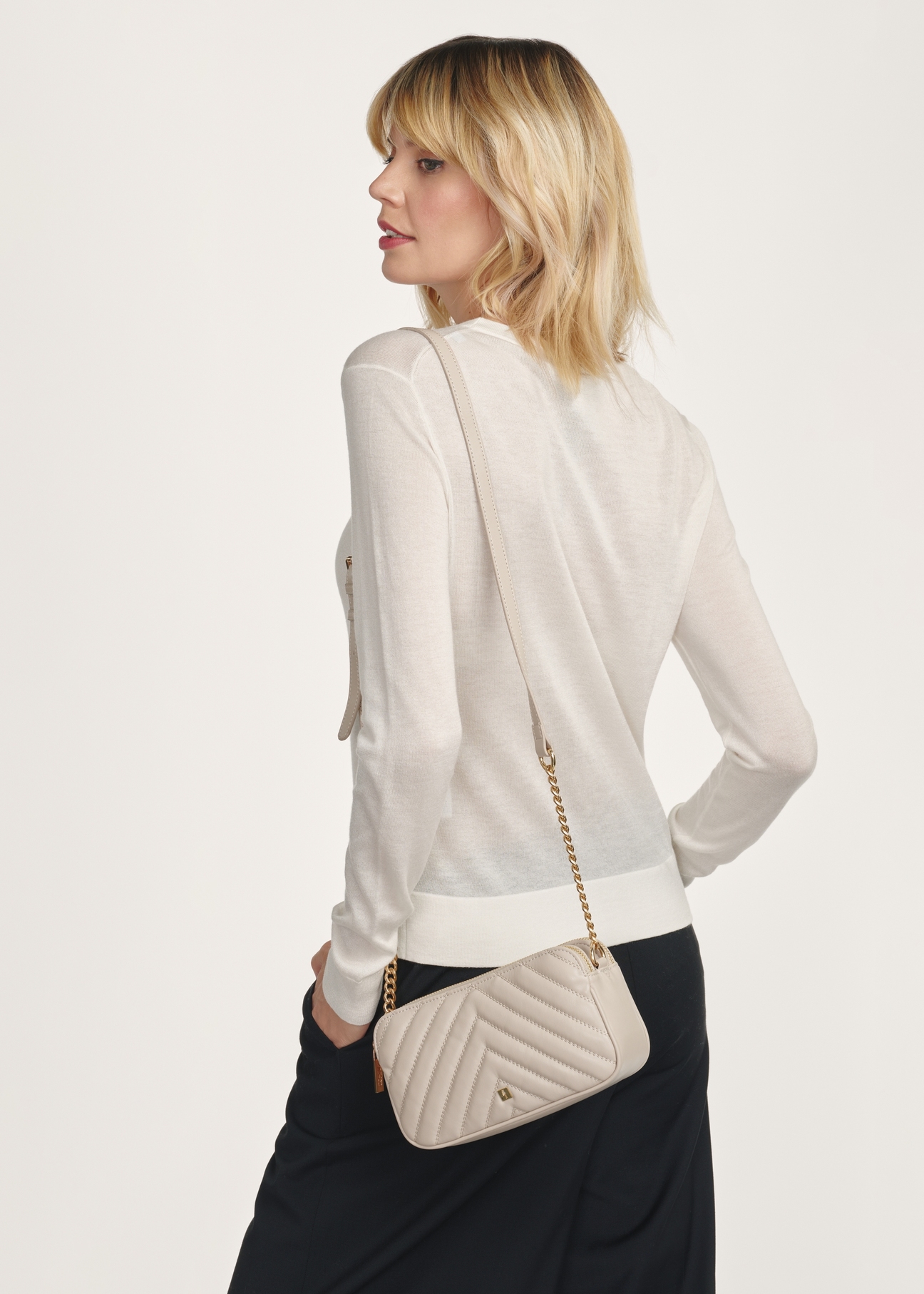 Small cream women's handbag TOREC-1051-12(Z25), front view of the product on the model, half of the silhouette visible.