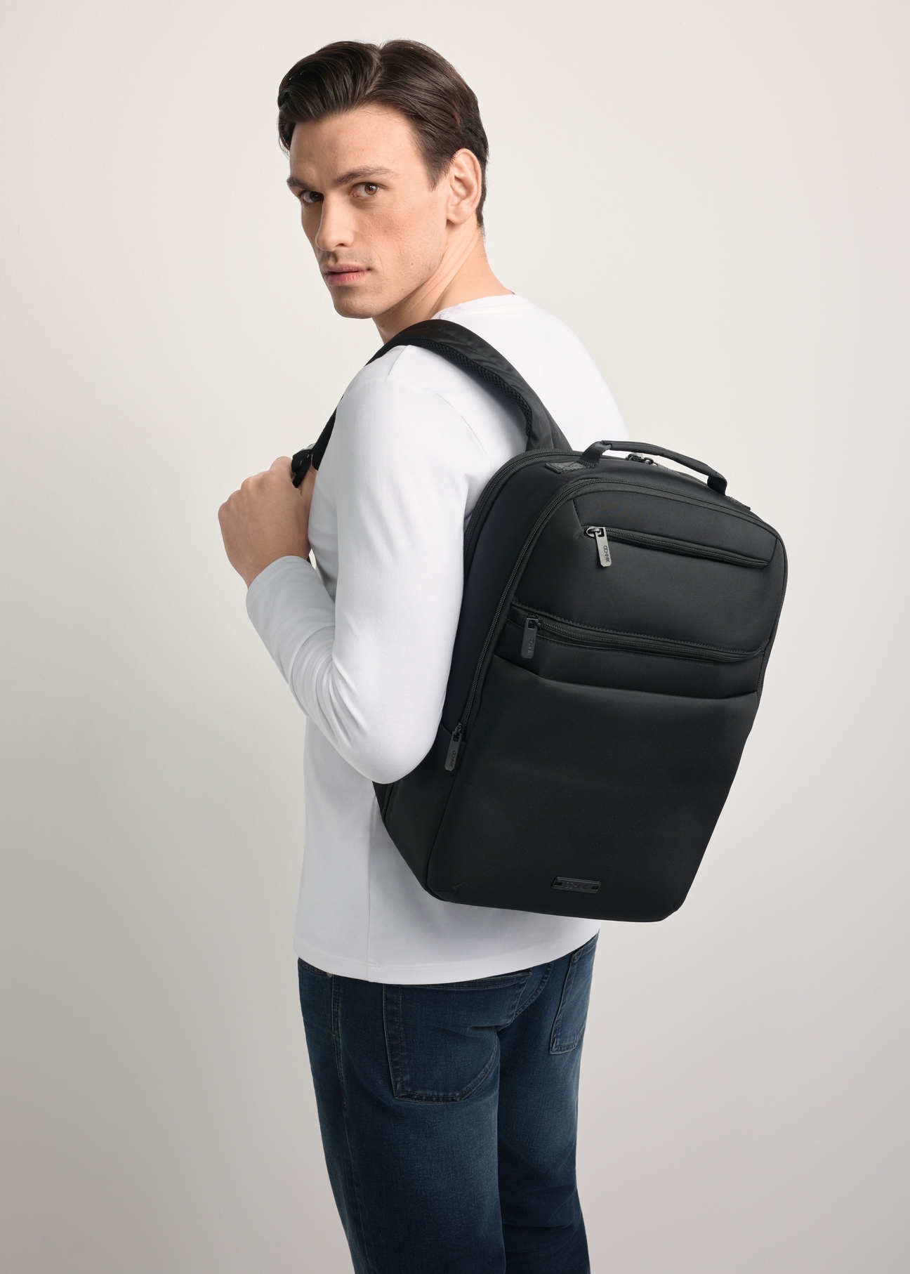 Black men's backpack TORMN-0368-99(Z25) - diagonal view of the product, against a light background. Half of the silhouette visible.