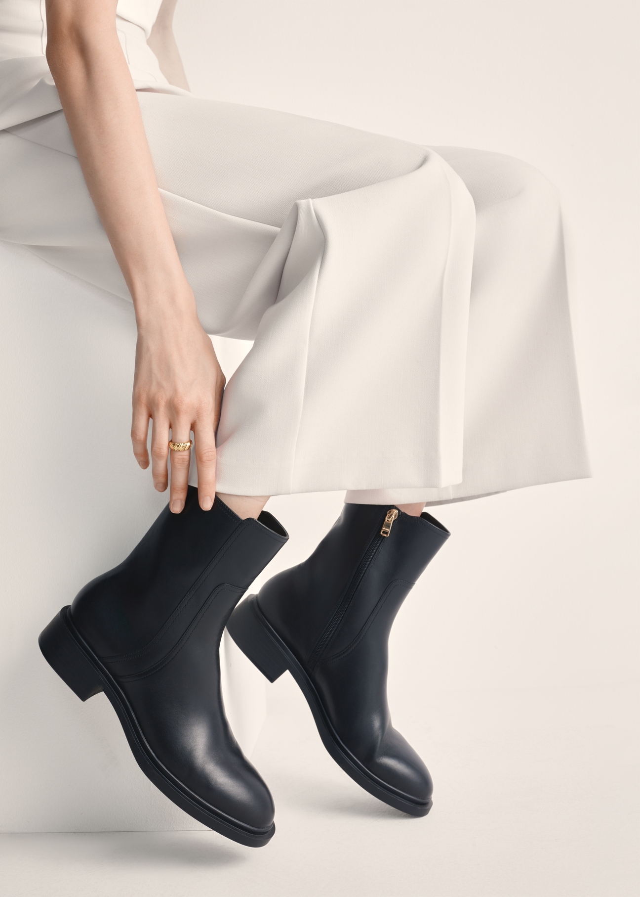 Black leather women's ankle boots BUTYD-1033-99(Z25), product view on model's feet against a light background.