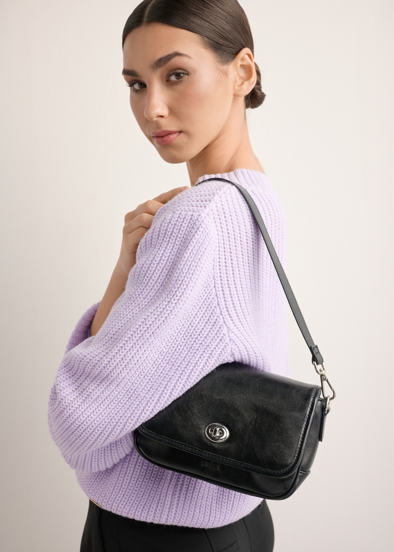 Small black women's handbag with gloss TOREC-1249-99(Z26), front view on model. Half of silhouette visible.