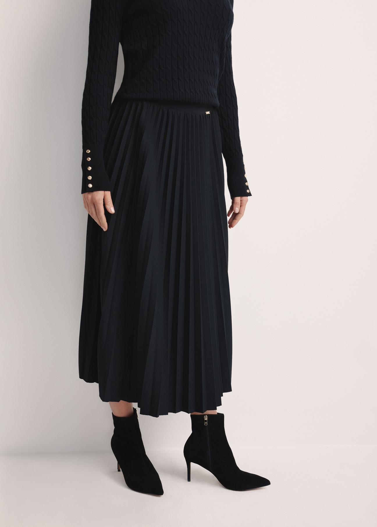 Black pleated women's dress SPCDT-0096-99(Z25), product visible from the front on the model, half of the silhouette visible.