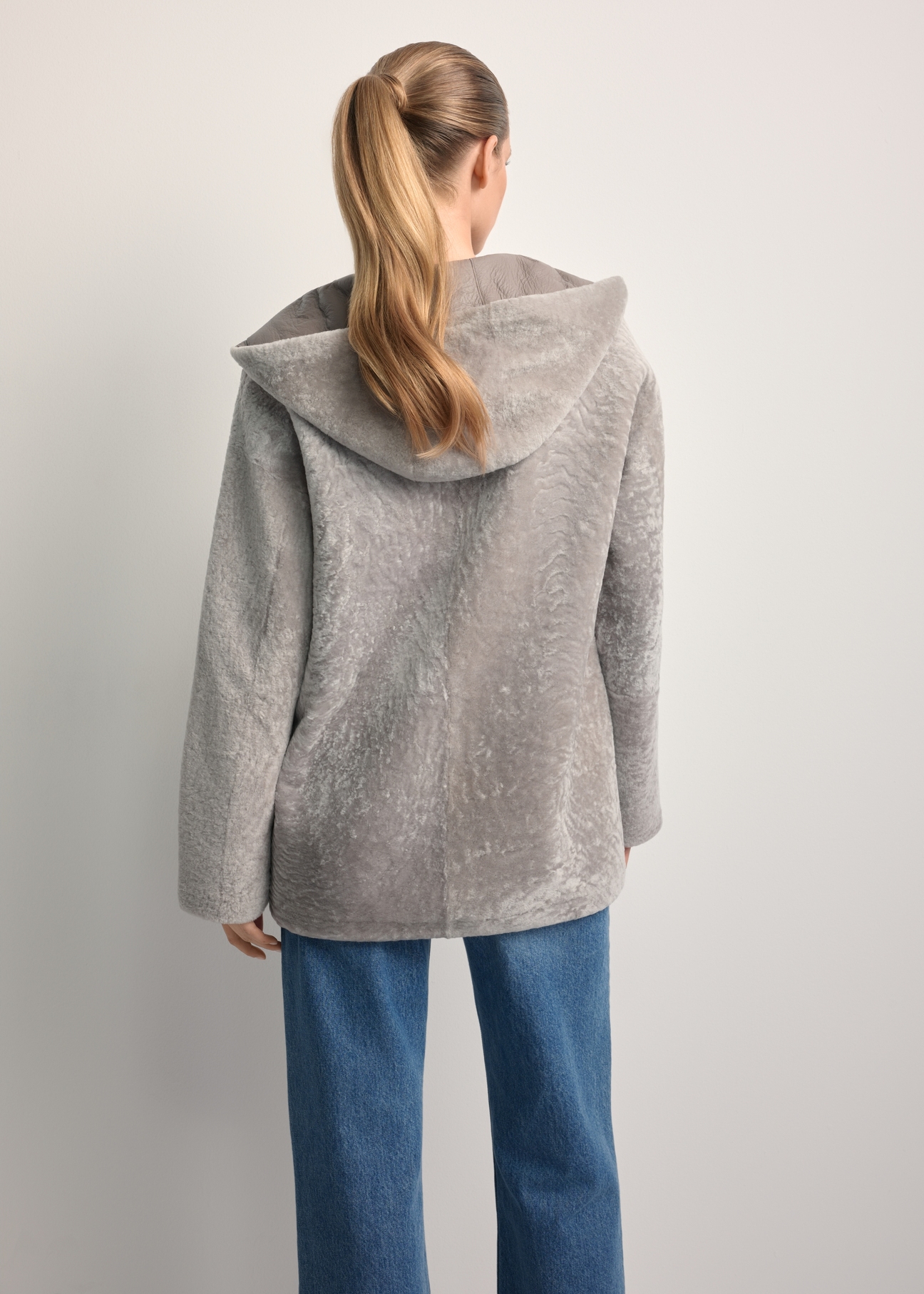 Light gray women's sheepskin coat KOZDS-0092-3098(Z25), back view of the product on the model. Half of the silhouette visible.