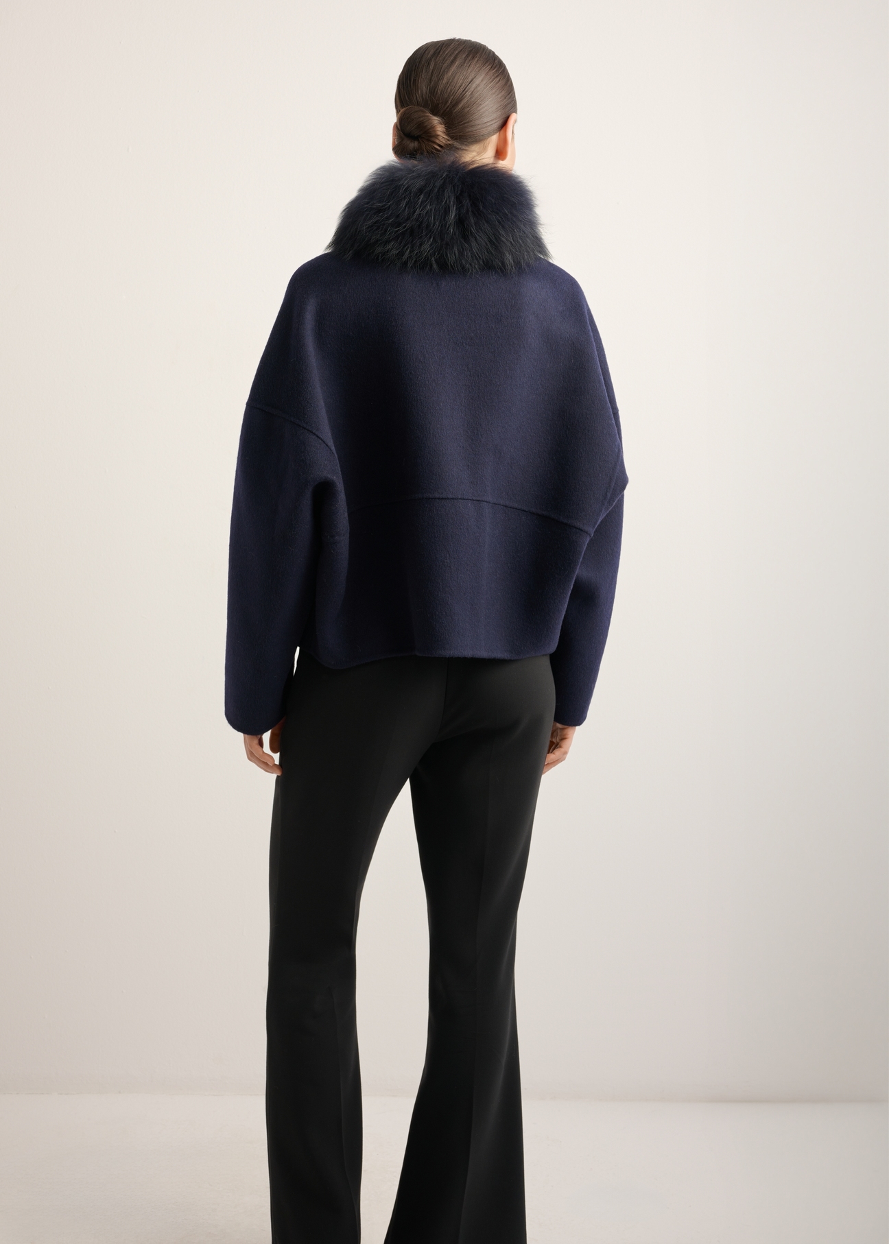 Women's short wool fur coat in navy blue FUTDW-0038-7E(Z26), back view of the product on the model. Half of the silhouette visible.