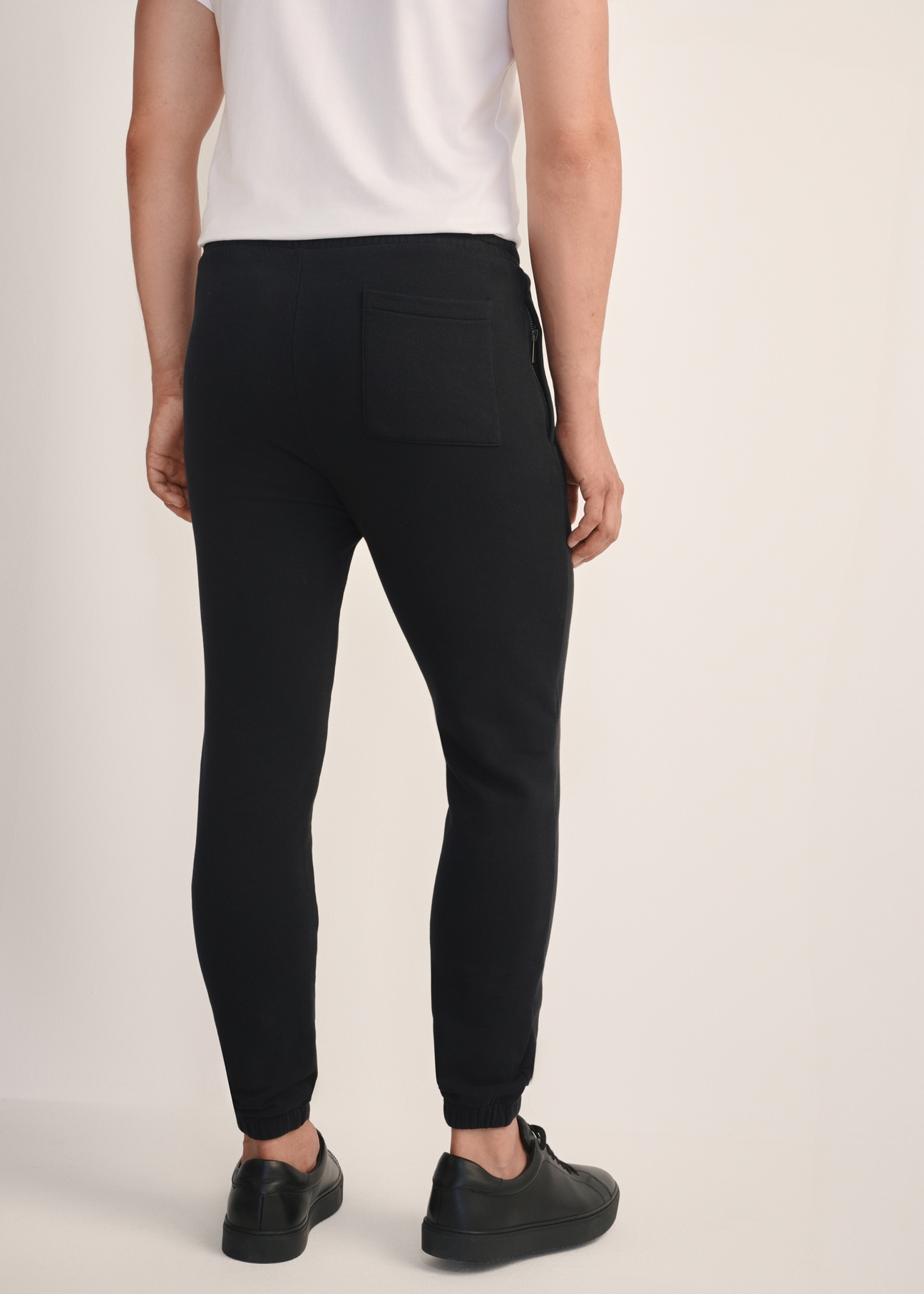Black men's sweatpants SPOMT-0101-99(Z25), product view from the back on the model, half of the silhouette visible.