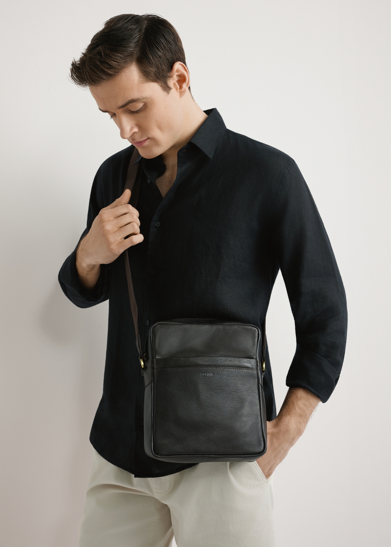 Men's dark brown leather bag TORMS-0502-1I(W26) - front view of the product, on a model, against a light background. Half of the silhouette visible.