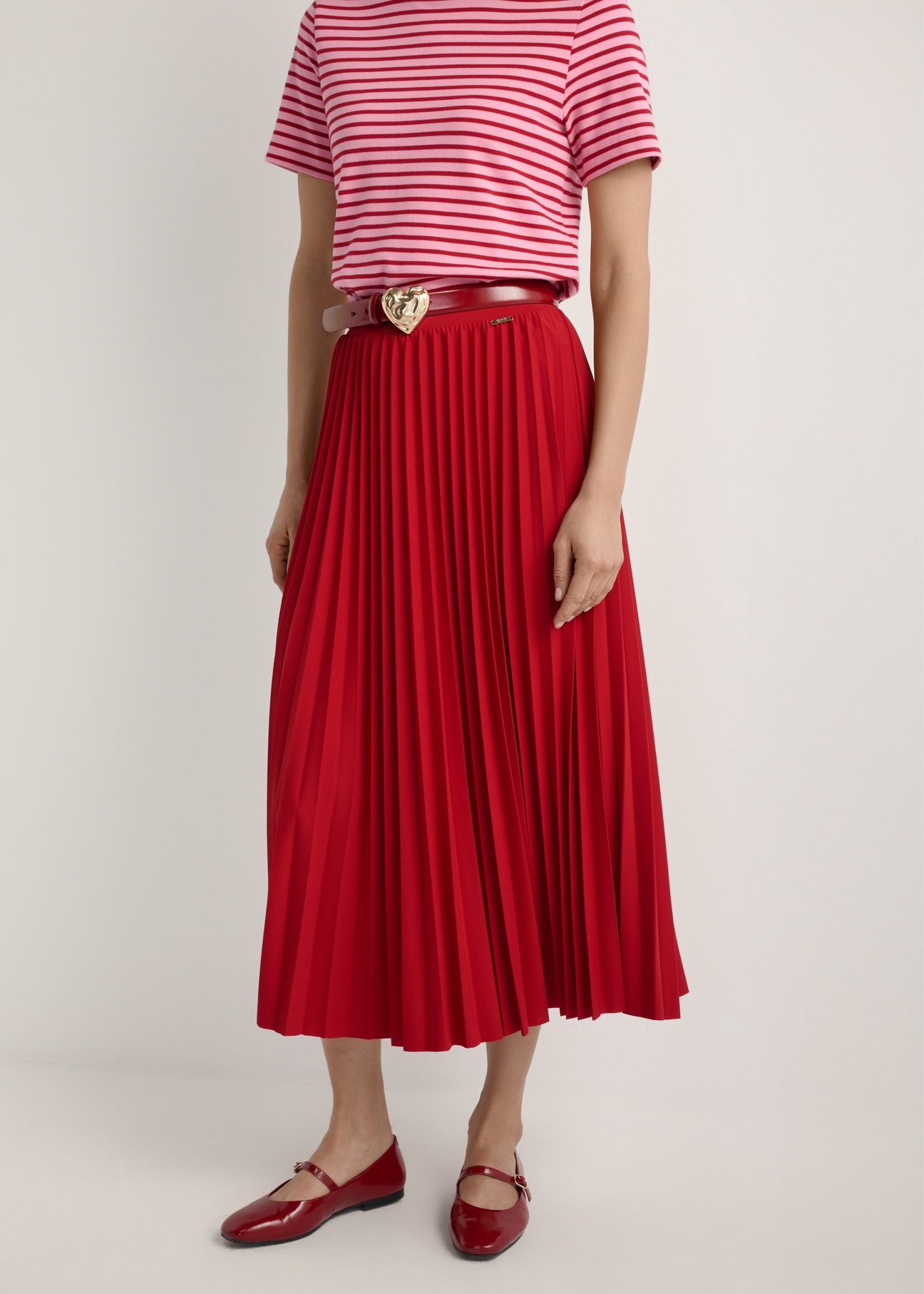 Red pleated midi skirt SPCDT-0096-4B(W26), product view from the front on the model, half of the silhouette visible.