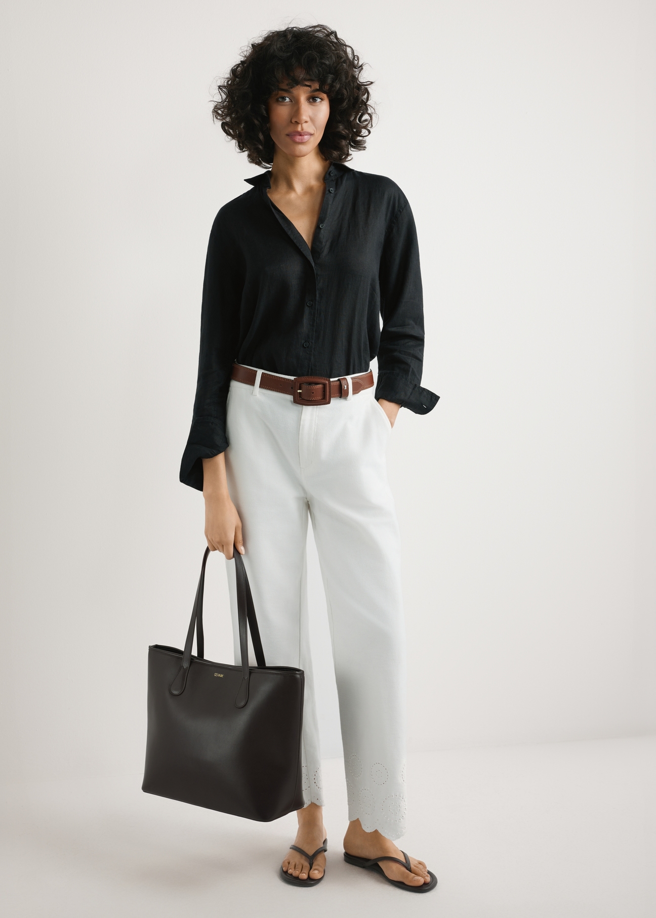 Brown women's shopper bag TOREC-1235-1H(W26), product view in model's hands. Full body visible.