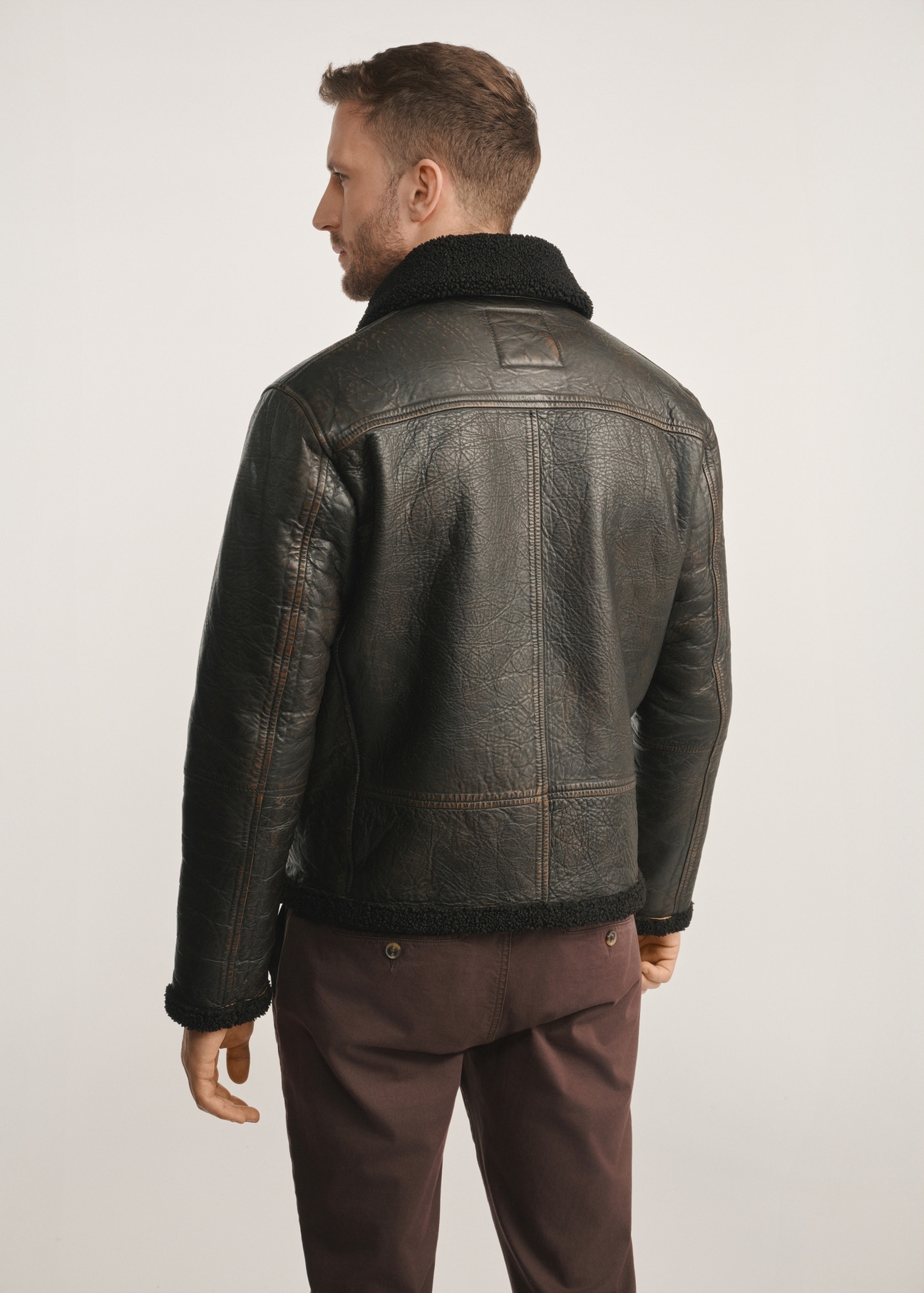 Brown men's leather jacket with sheepskin KURMS-0386-0704(Z25), product view from the back on the model, half of the silhouette visible.