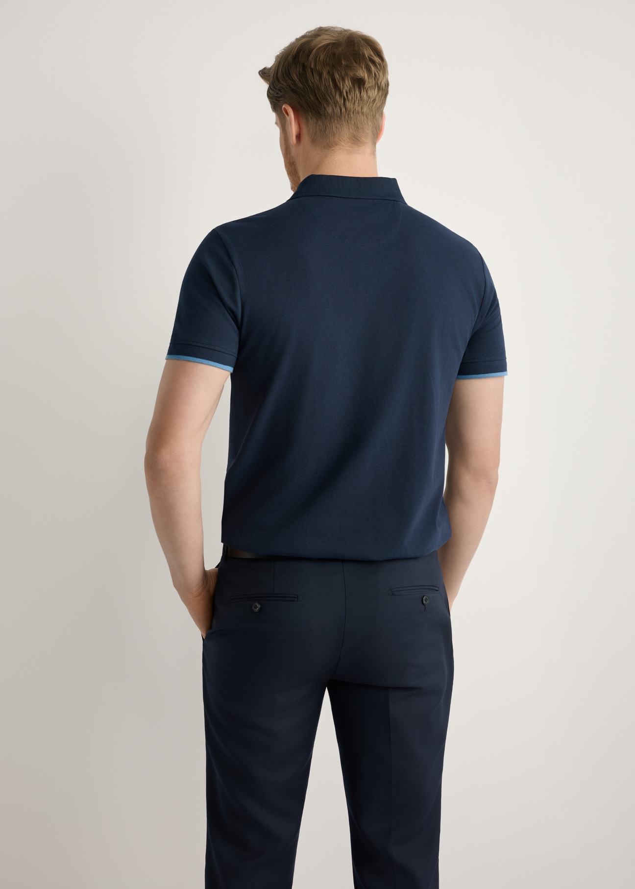 Navy blue cotton polo shirt POLMT-0045B-7E(W26), back view of the product on the model. Half of the silhouette visible.