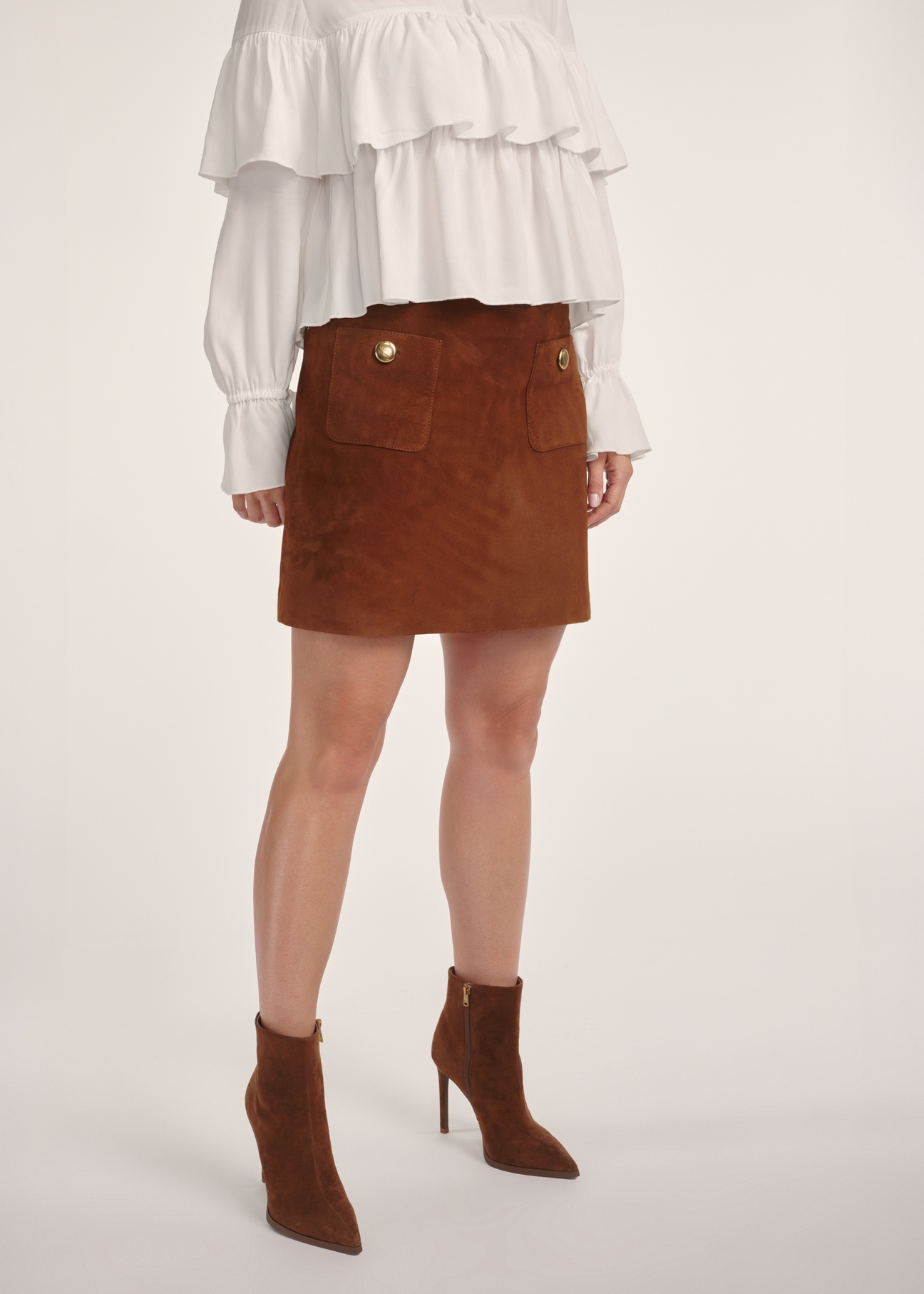 Suede mini skirt in cognac color SPCDS-0078-3205(Z25), product visible from the front on the model, half of the silhouette visible.