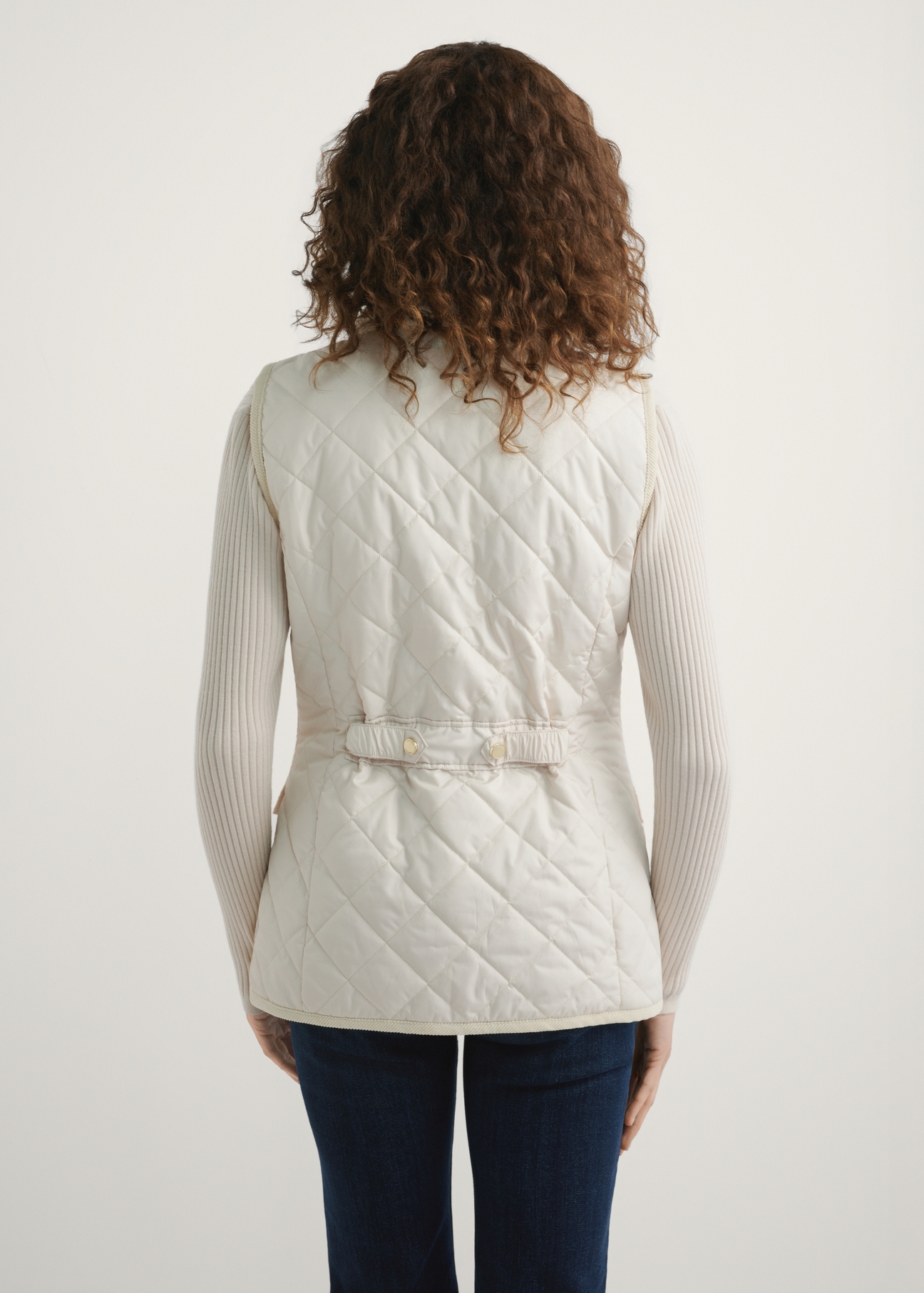 Light beige women's quilted vest KAMDT-0036-0B(W26) - back view of the product, on a model, against a light background. Half of the silhouette visible.