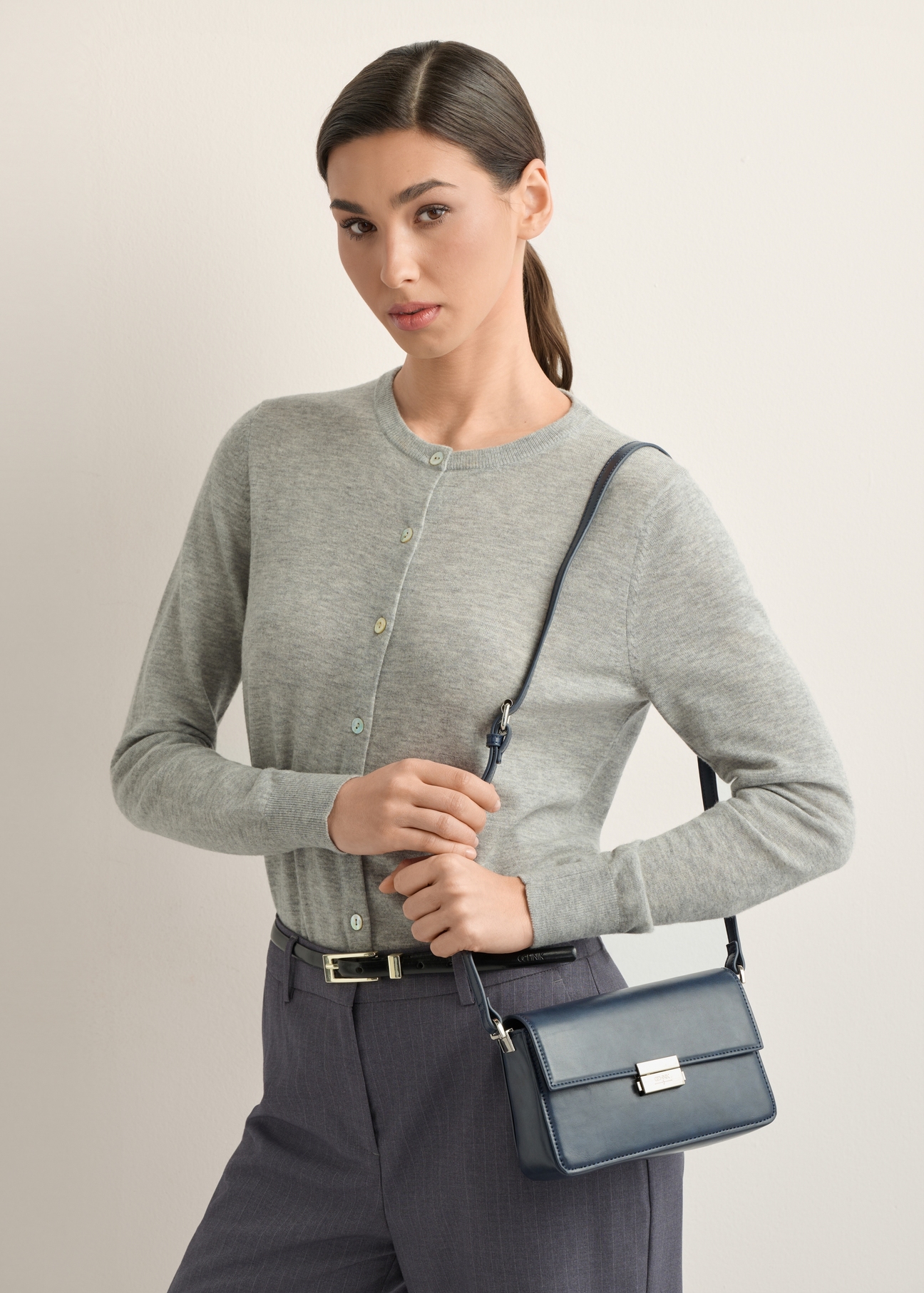Elegant navy blue women's handbag TOREC-1251-7E(Z26), diagonal view of the product on the model. Half of the silhouette visible.
