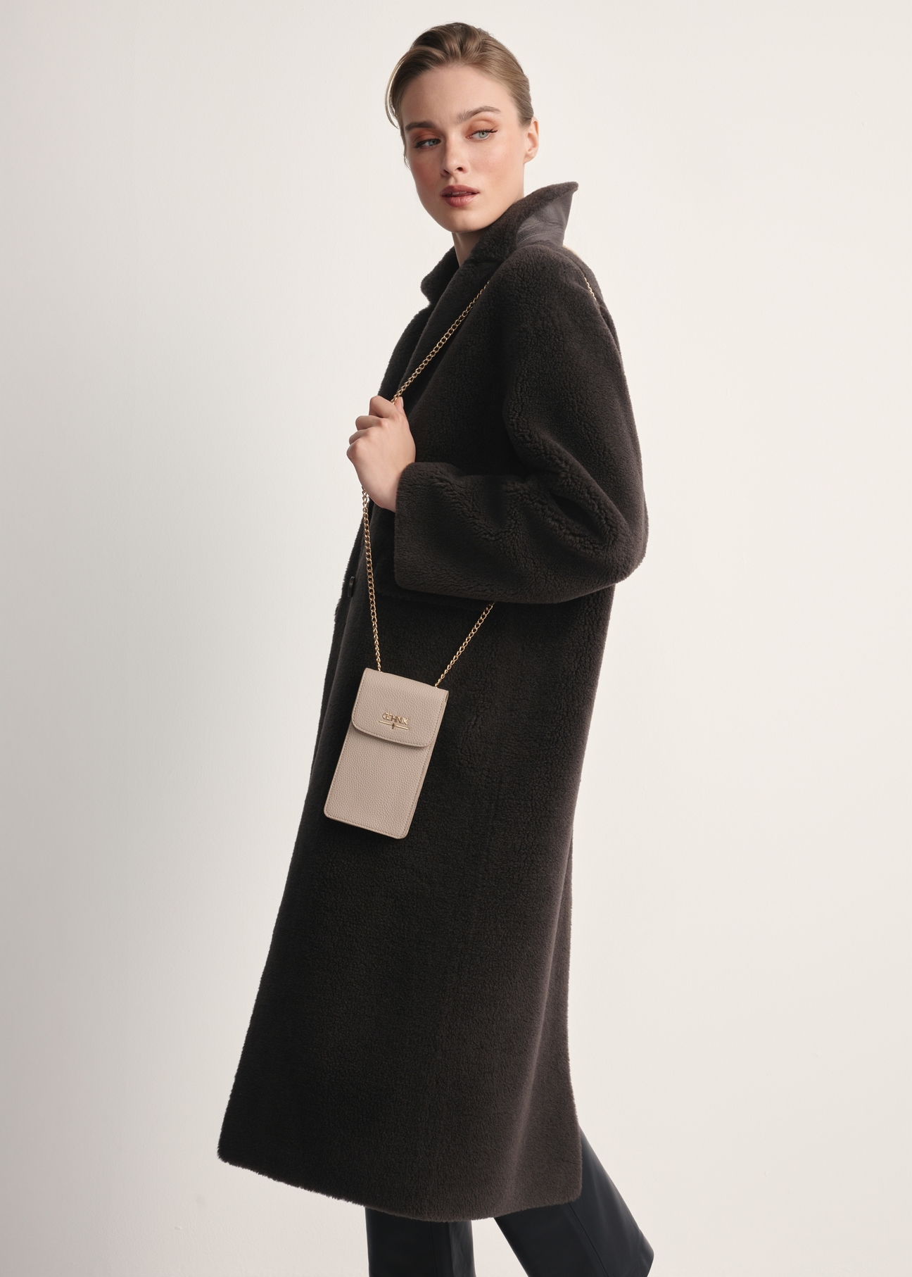 Beige women's pouch TOREC-1112-80(Z25) - front view of the product on a model against a white background. The entire silhouette is visible from the side.