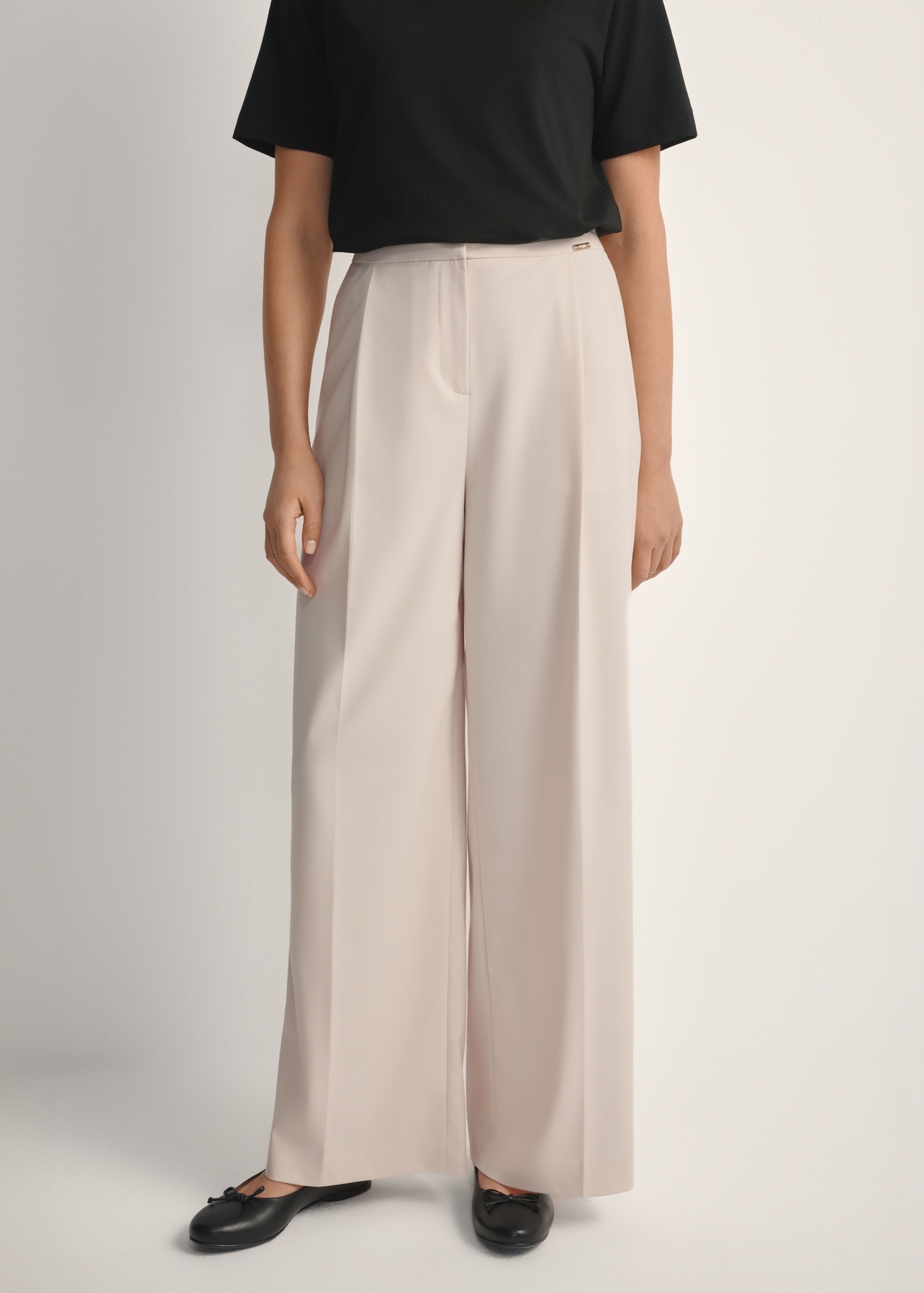 Light beige women's trousers SPODT-0119-1A(W26), front view of the product on the model. Half of the silhouette visible.