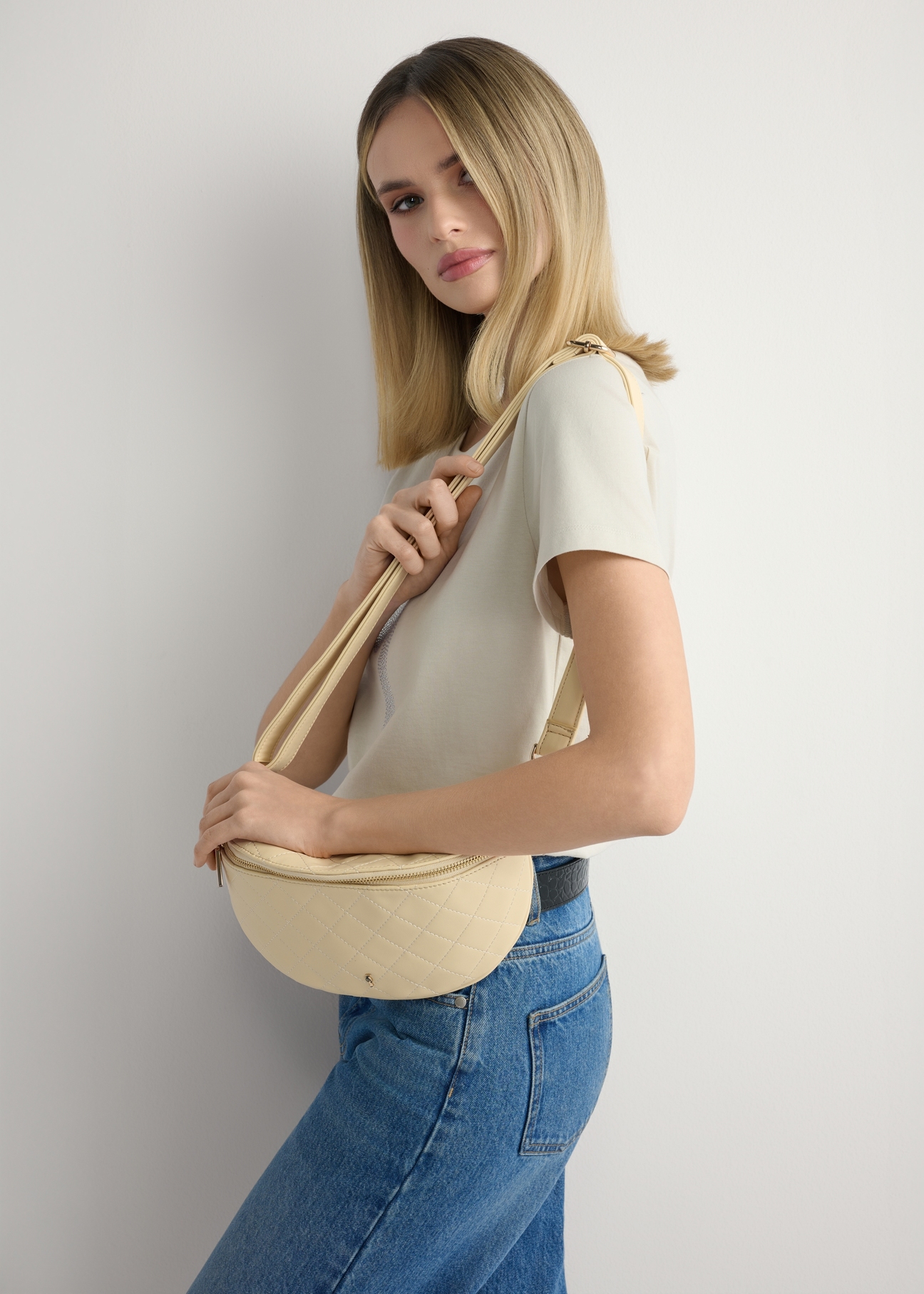 Women's quilted light yellow waist bag TOREC-0878-2A(W26), product view on model's shoulder. Half silhouette visible.