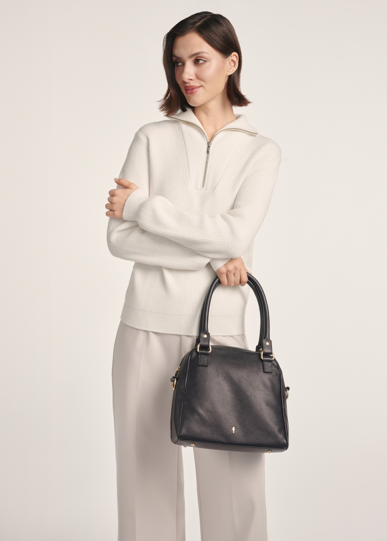 Black leather women's handbag TORES-1183-99(Z25), front view of the product on a model, half of the silhouette visible.