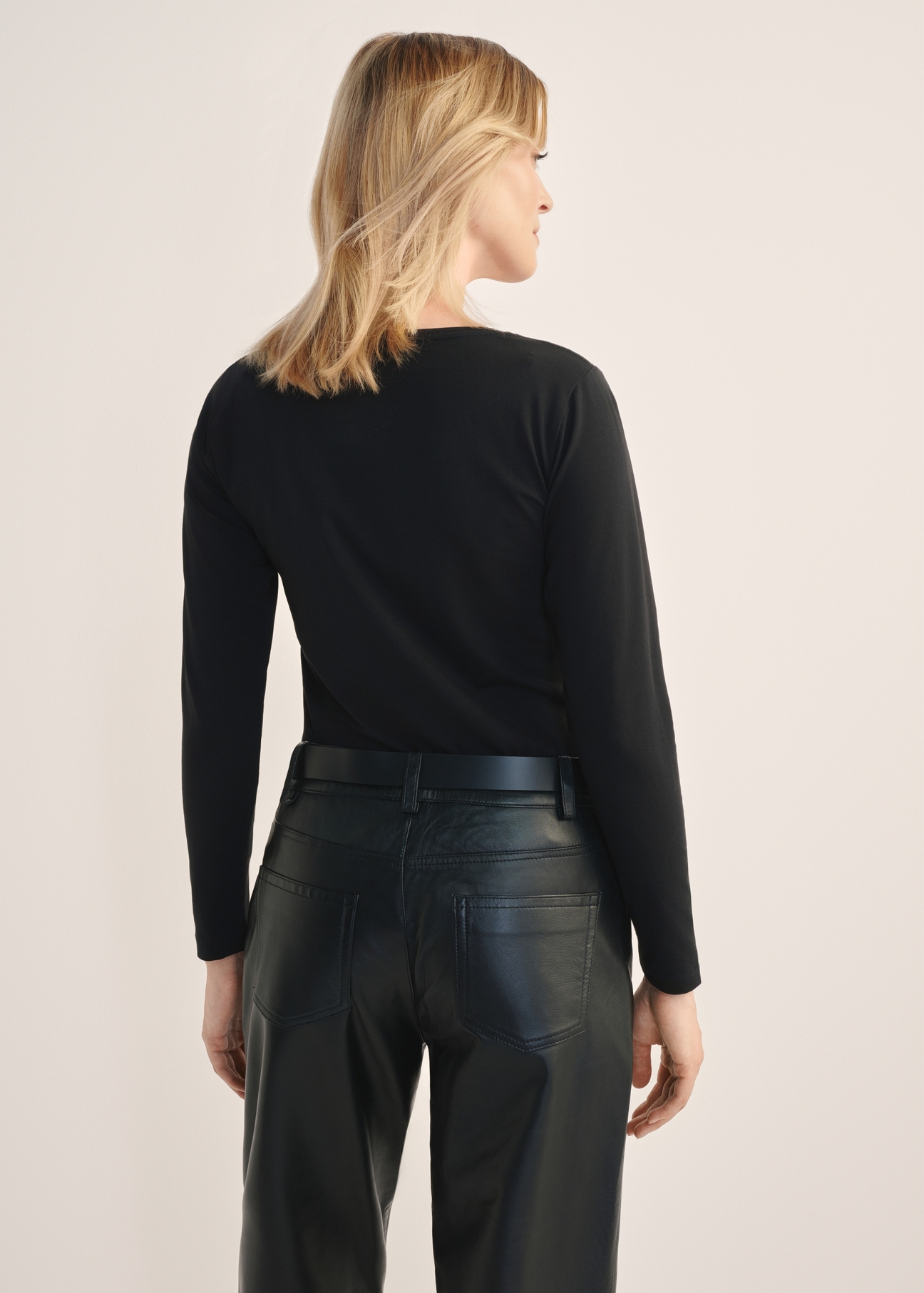 Black women's blouse with long sleeves LSLDT-0038-99(KS), product view from the back on the model, half of the silhouette visible.