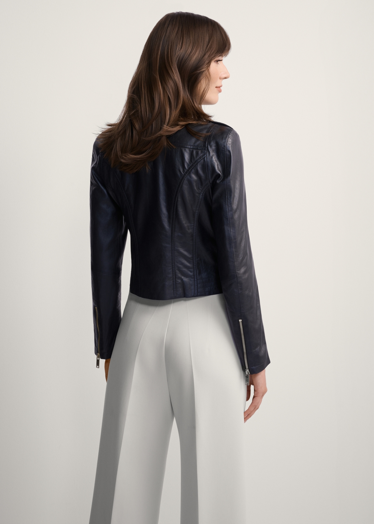 Women's black leather biker jacket KURDS-0323A-1116(KS), back view of the product on the model. Half of the silhouette visible.