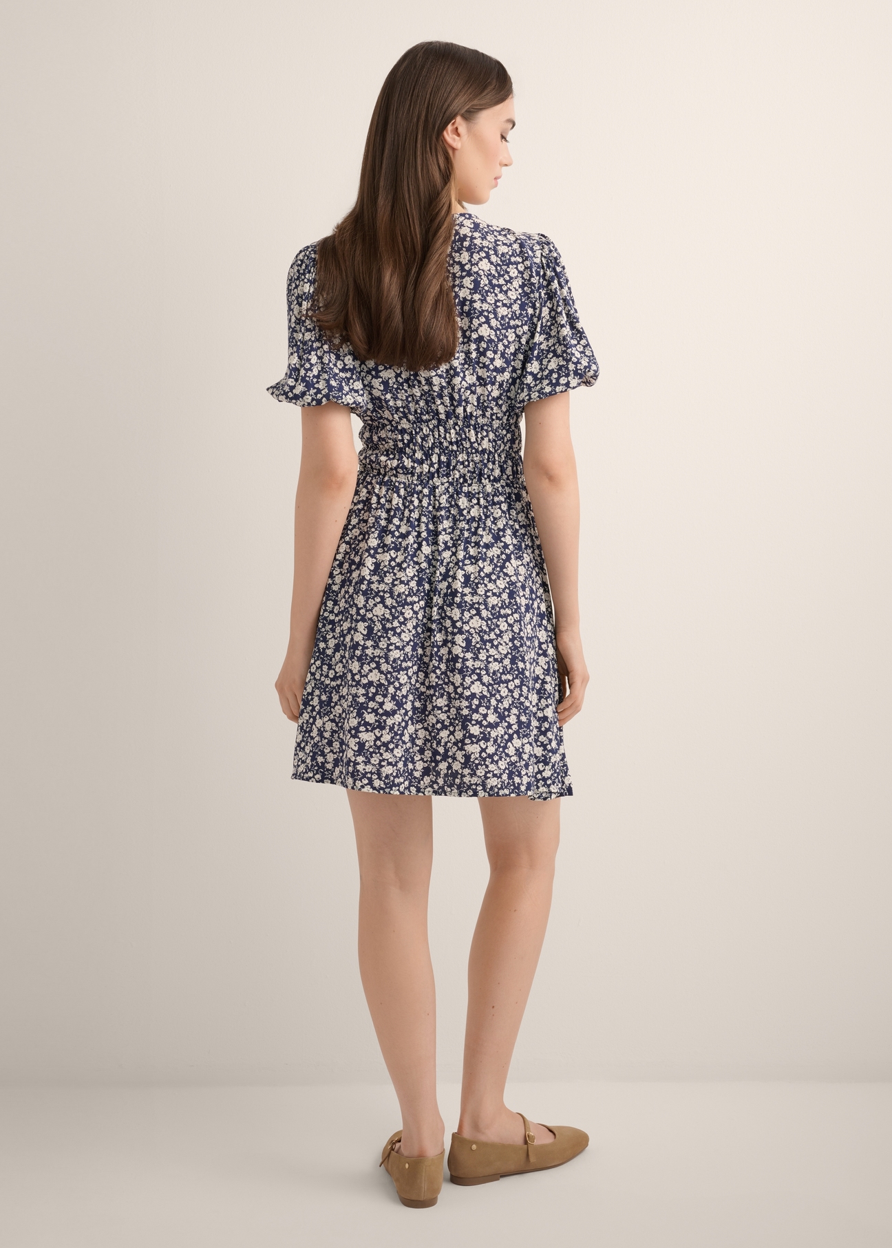 Short floral dress SUKDT-0226-7P(W26), back view of the product on the model. Full body visible.