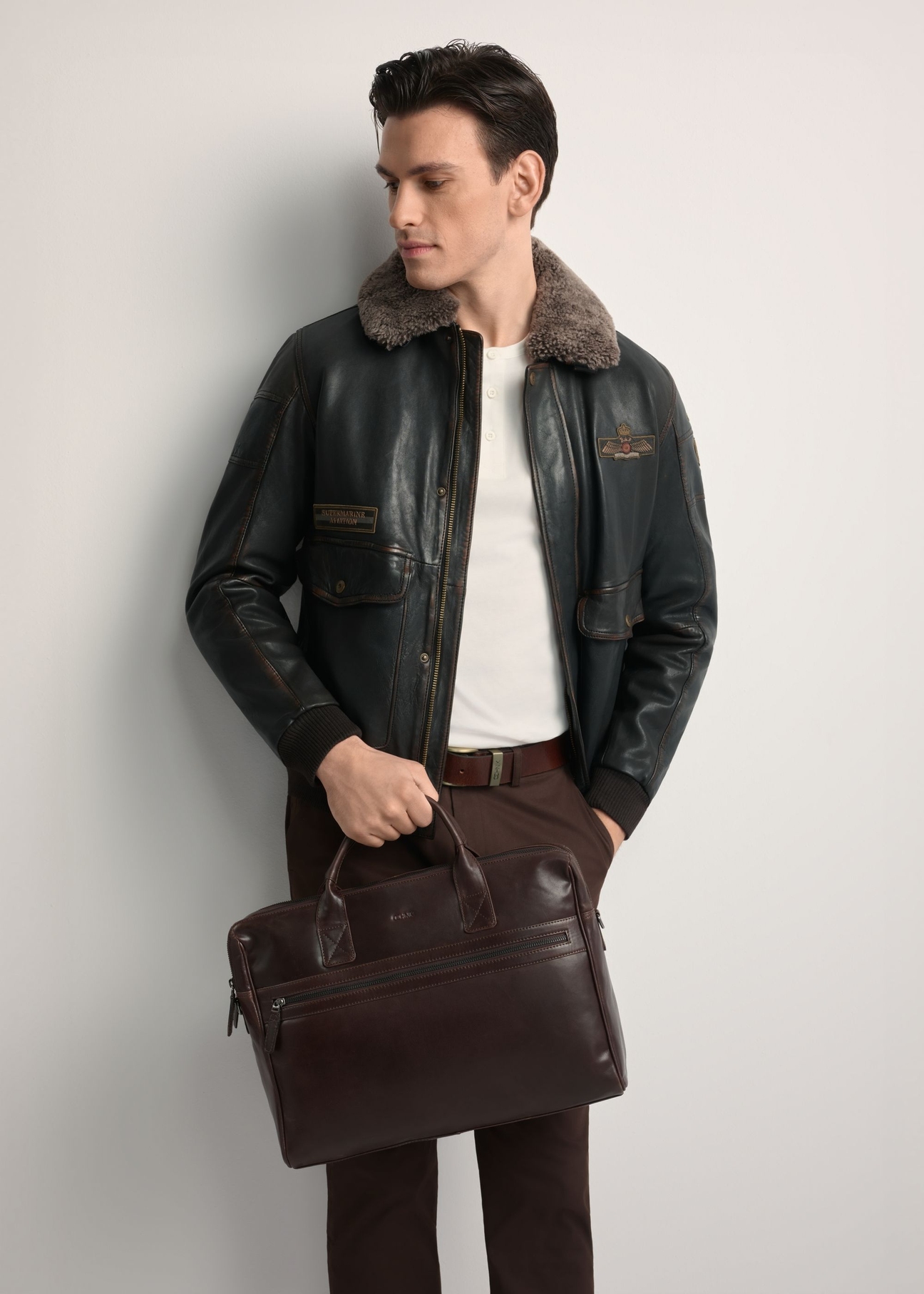 Brown leather men's bag TORMS-0460-1H(Z26) - front view of the product, held by the model. Half of the silhouette visible.