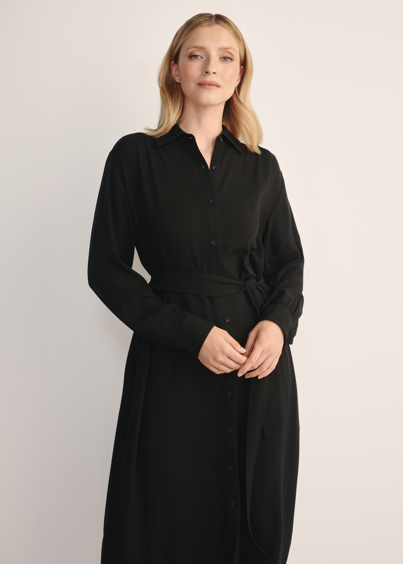 Women's black long-sleeved dress SUKDT-0246-99(Z25), front view of the product on the model. Half of the silhouette visible.