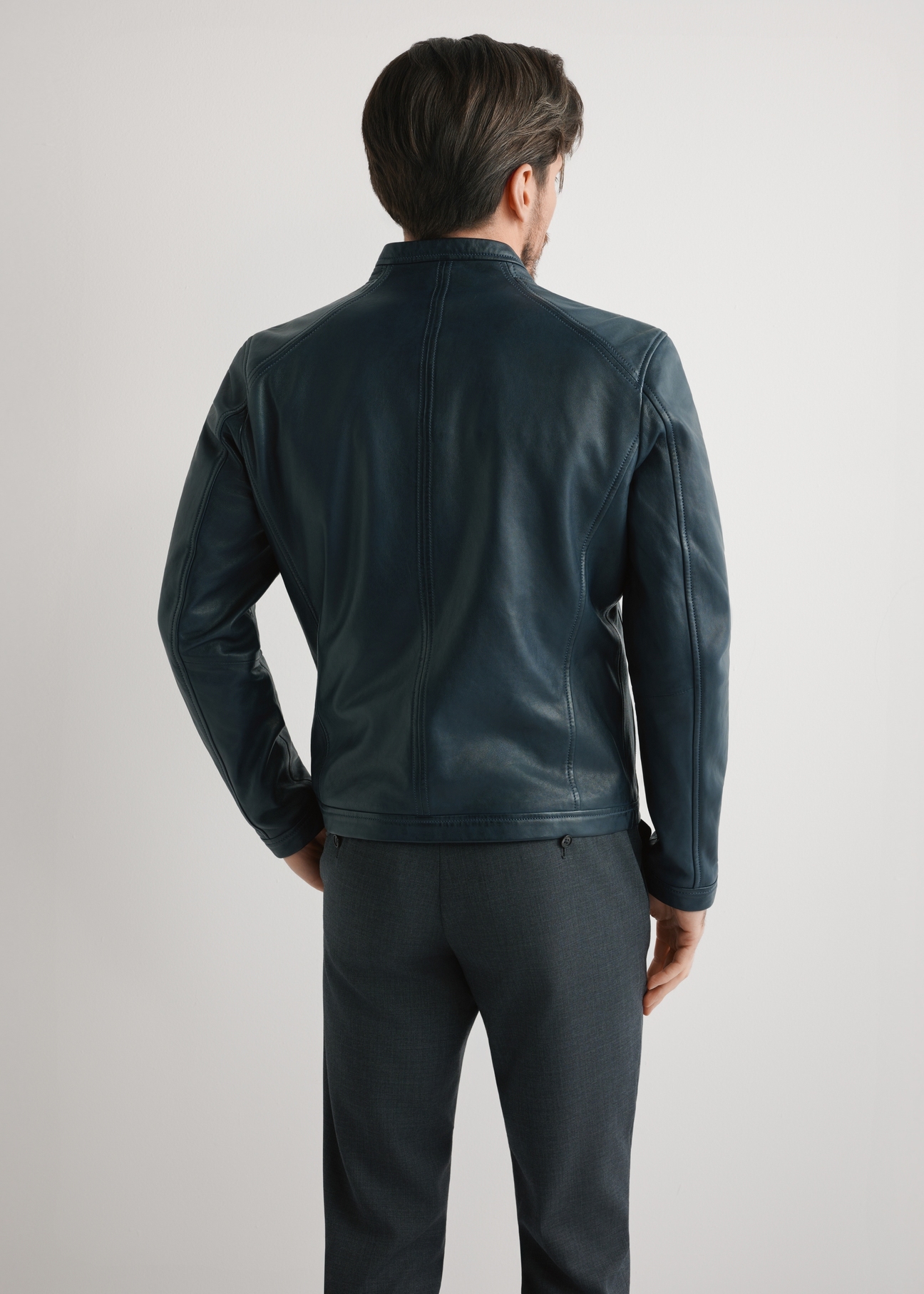 Navy blue men's leather jacket KURMS-0329-7E(W26) - rear view of the product on the model, against a light background. Knee-length silhouette visible.