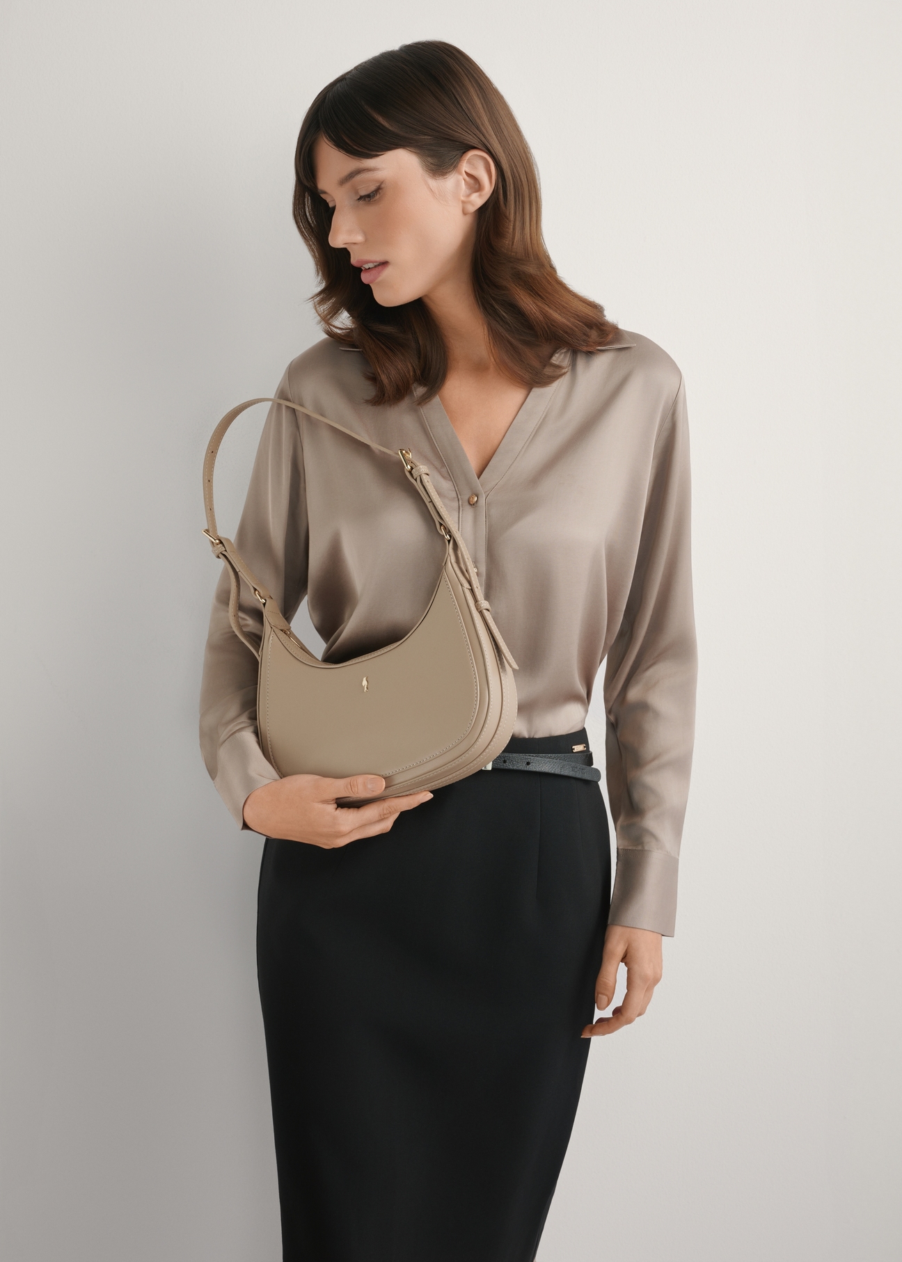Beige small hobo bag TOREC-1136-1A(W26), product view in model's hand. Half of silhouette visible.