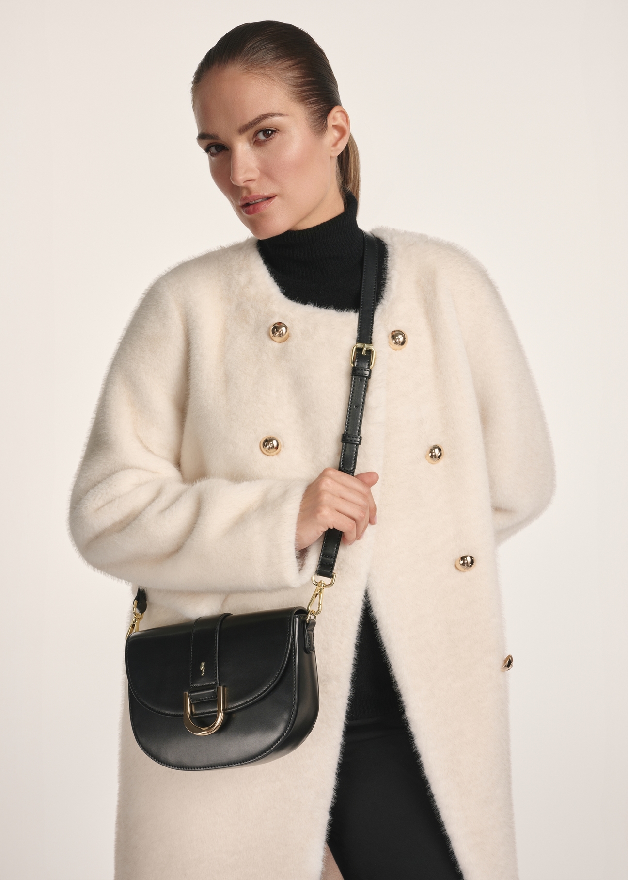 Black classic women's handbag TOREC-0879B-99(Z25), product view from the front on a model, view on a white background.