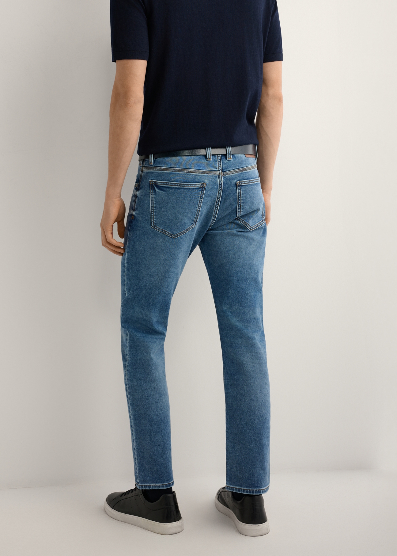 Men's dark blue jeans JEAMT-0021-7H(W26), product view from the back on the model. Half of the silhouette visible.
