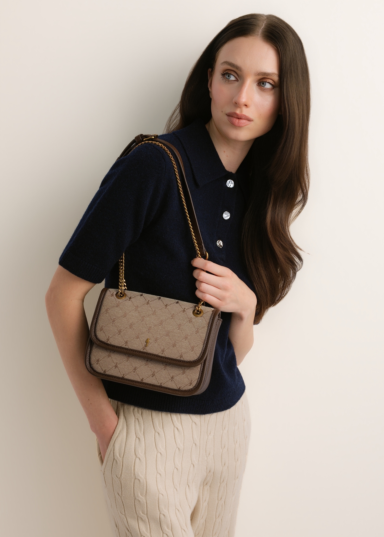 Beige women's handbag with a monogram (TOREN-0360-1B(Z26)); front view of the product shown on a model's shoulder.