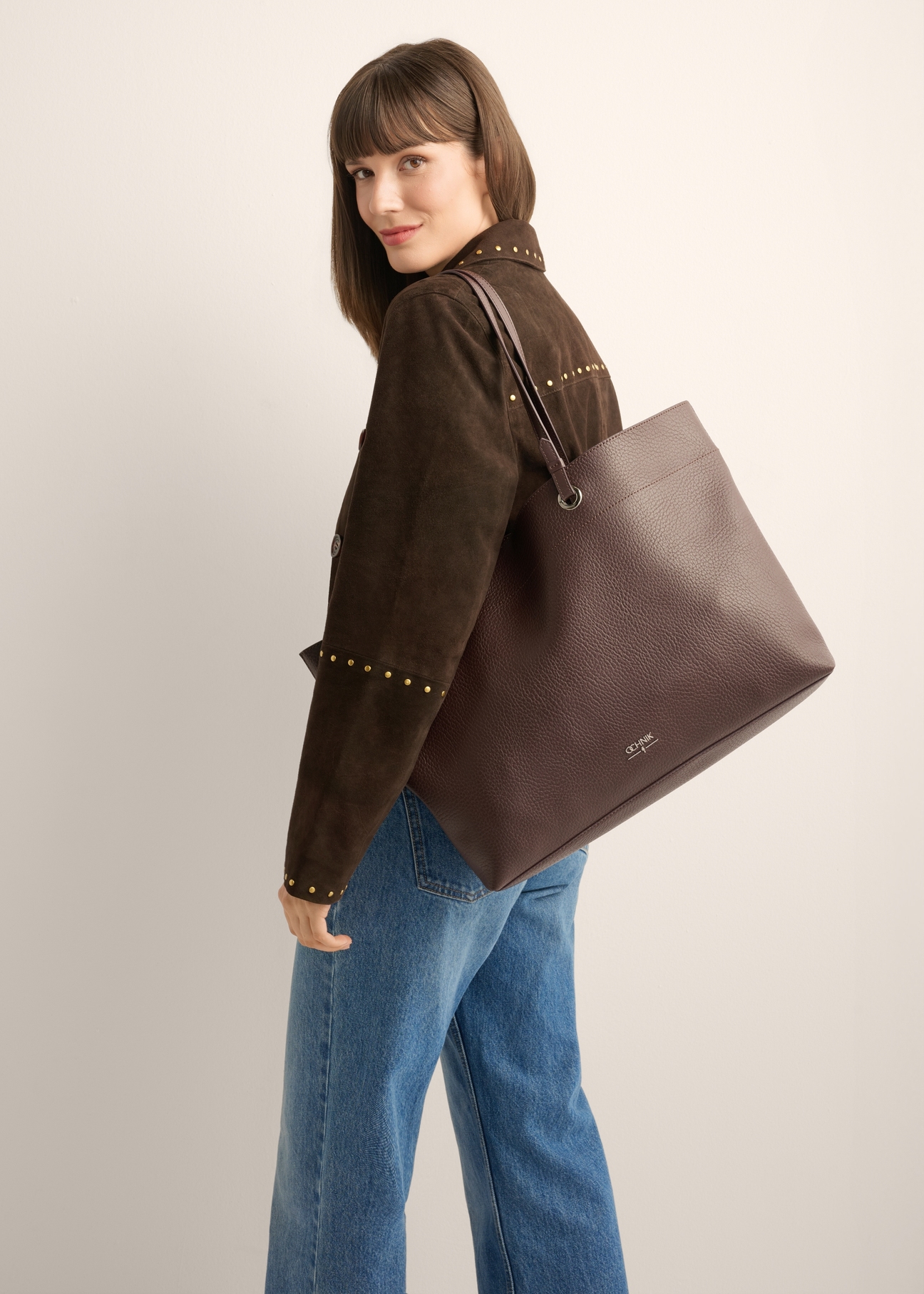 Brown pebbled shopper bag TOREC-1252-1I (Z26), front view of the product on a model. Half of the silhouette visible.