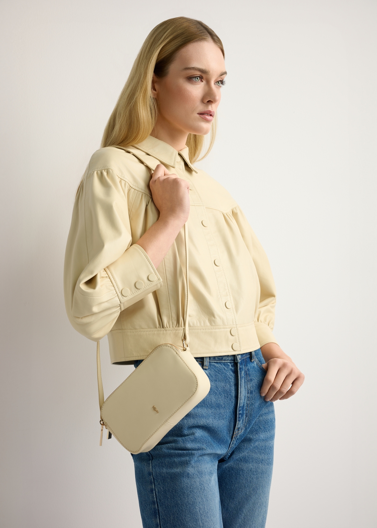 Light yellow leather women's handbag TORES-1289-2A(W26), front view of the product on the model's shoulder. Half of the silhouette visible.