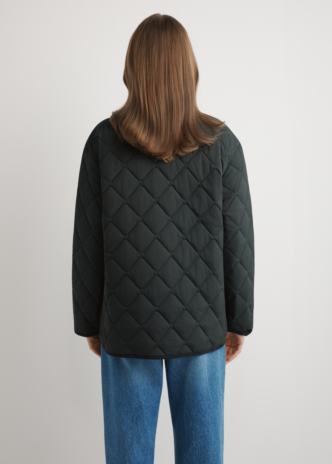 Women's black quilted jacket KURDT-0580-99(W26) - back view of the product, on a model, against a light background. Knee-length silhouette visible.