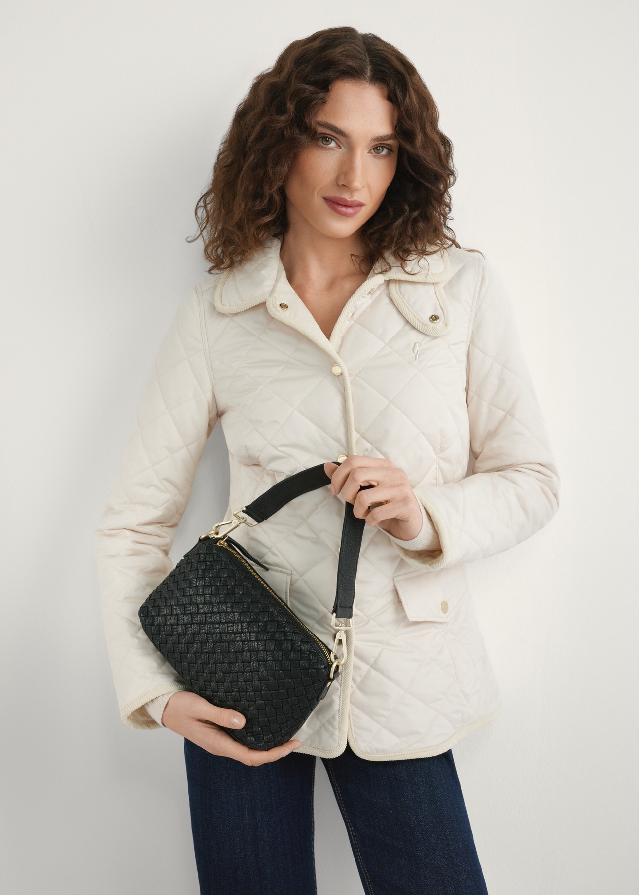 Black leather handbag with decorative weave TORES-1243-9P(W26), front view of the product on a model, half of the silhouette visible.