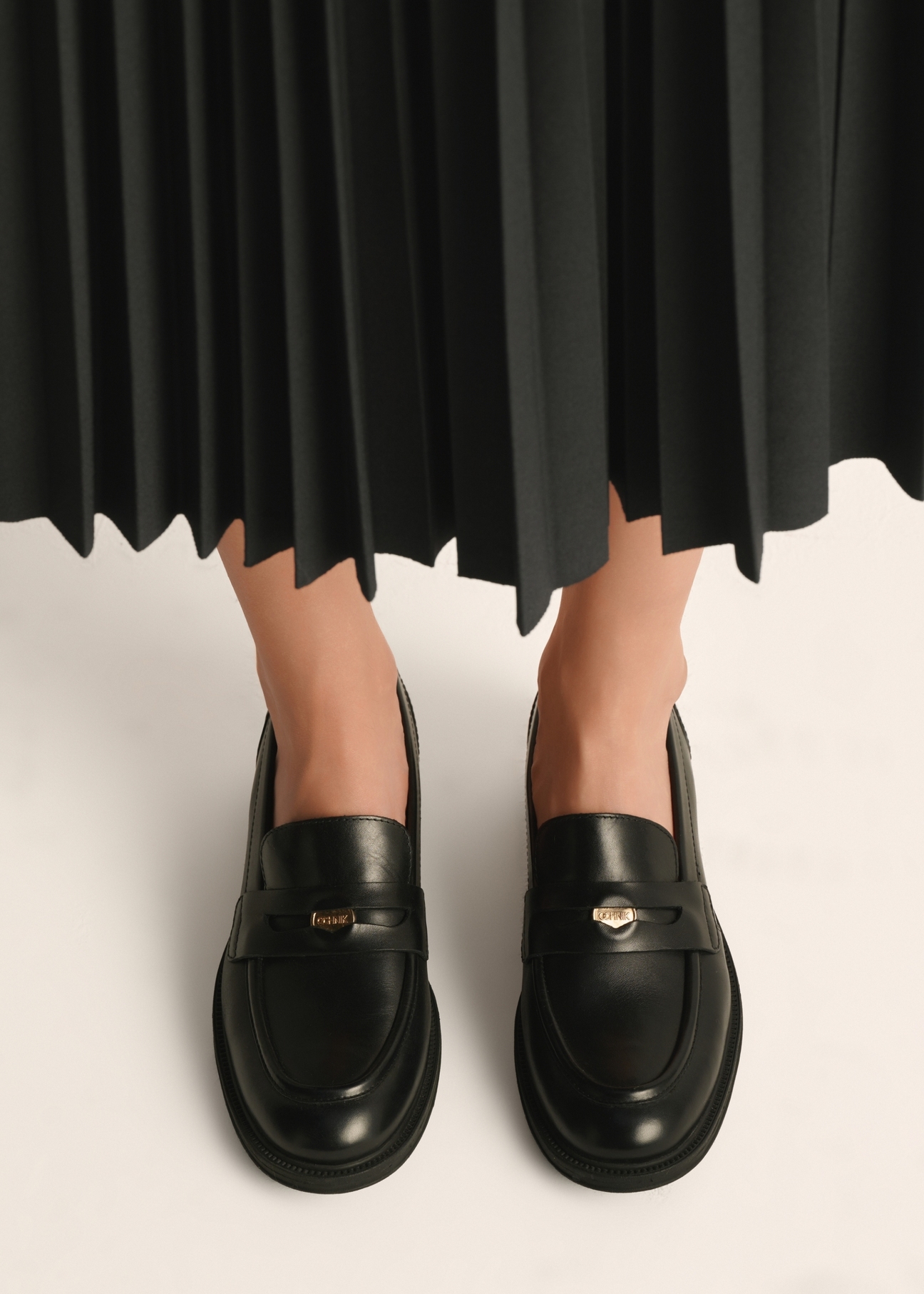Women's black leather moccasins with logo BUTYD-1199-99(Z25) - top view of the product on a model on a white background.