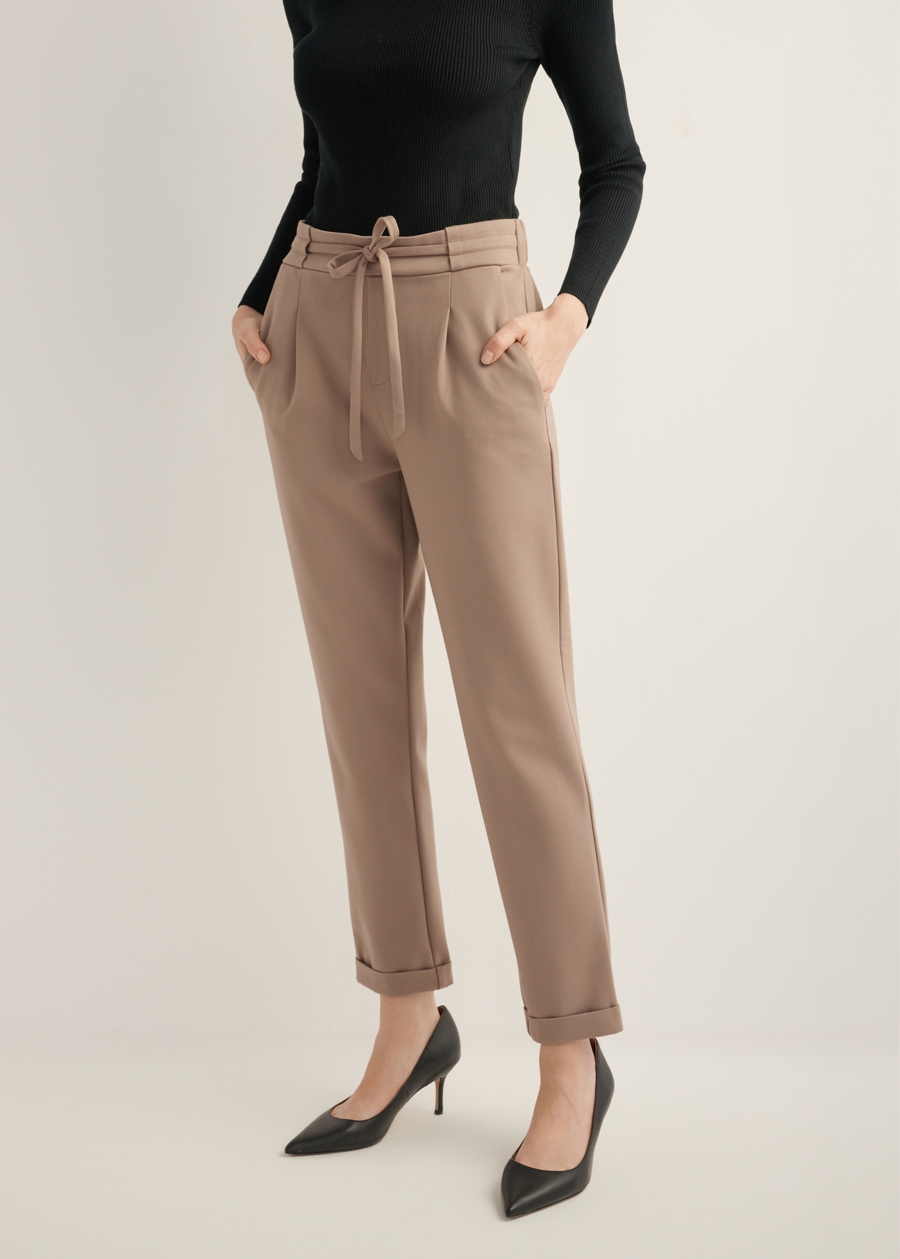 Women's trousers with a crease in a cool beige color SPODT-0098-1K(Z26), front view of the product on the model, half of the silhouette visible.