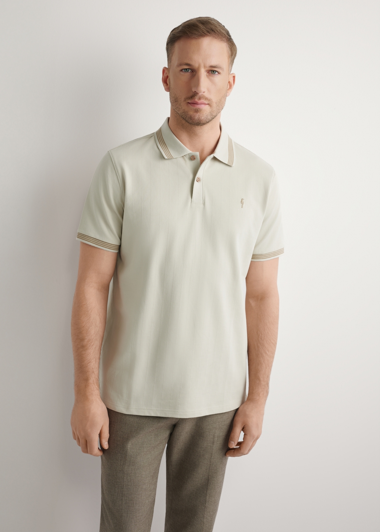 Light beige polo shirt POLMT-0090-1A(W26), front view of the product on the model. Half of the silhouette visible.
