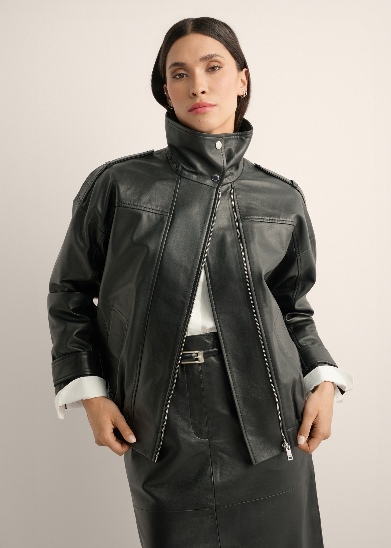 Black oversized leather jacket KURDS-0623-99(Z26), front view of the product on the model. Half of the silhouette visible.