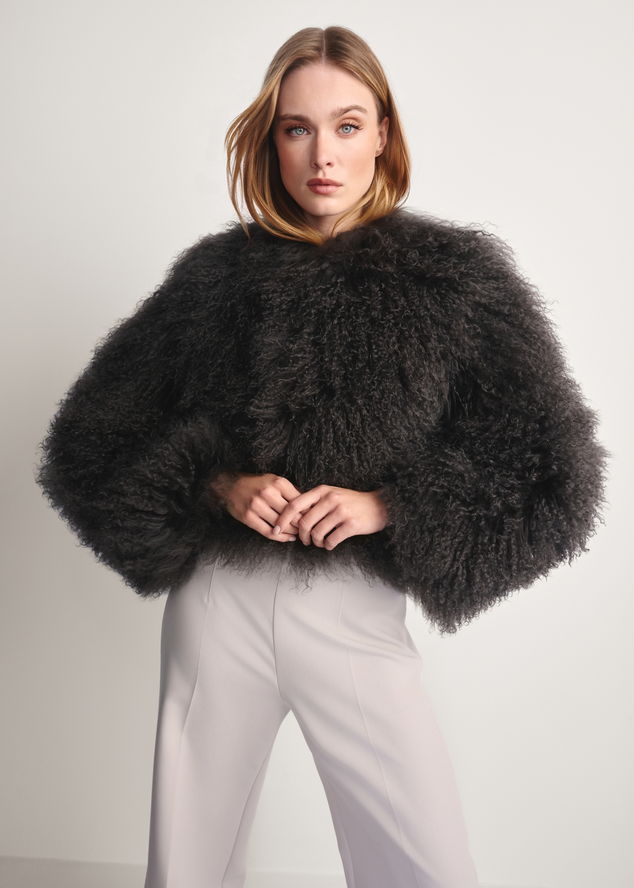 Gray short natural fur FUTDF-0104-3178(Z25) - front view of the product on a model on a white background. Half of the silhouette visible.