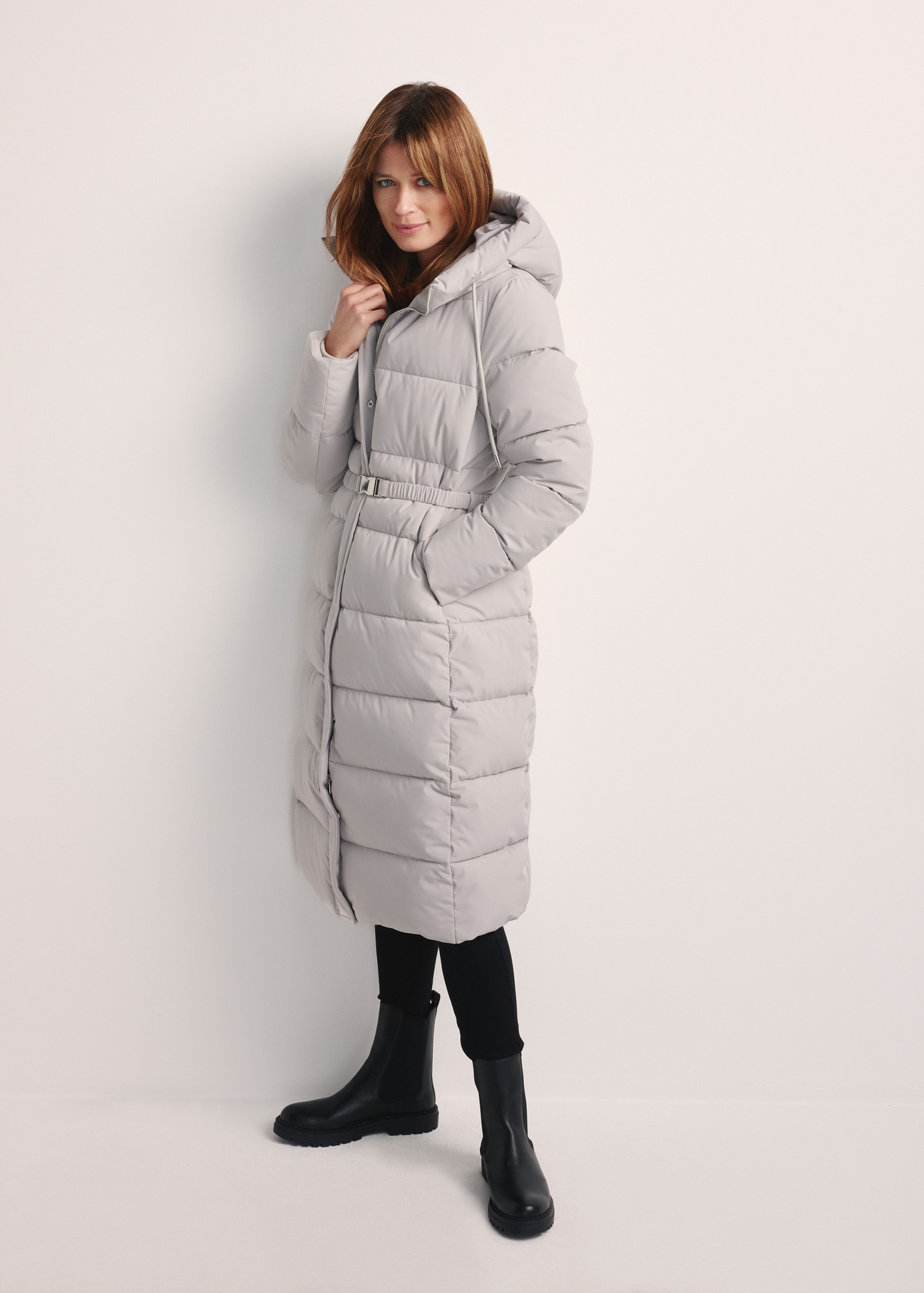 Long light gray women's jacket KURDT-0602-66(Z25), front view of the product on the model. The entire silhouette is visible.