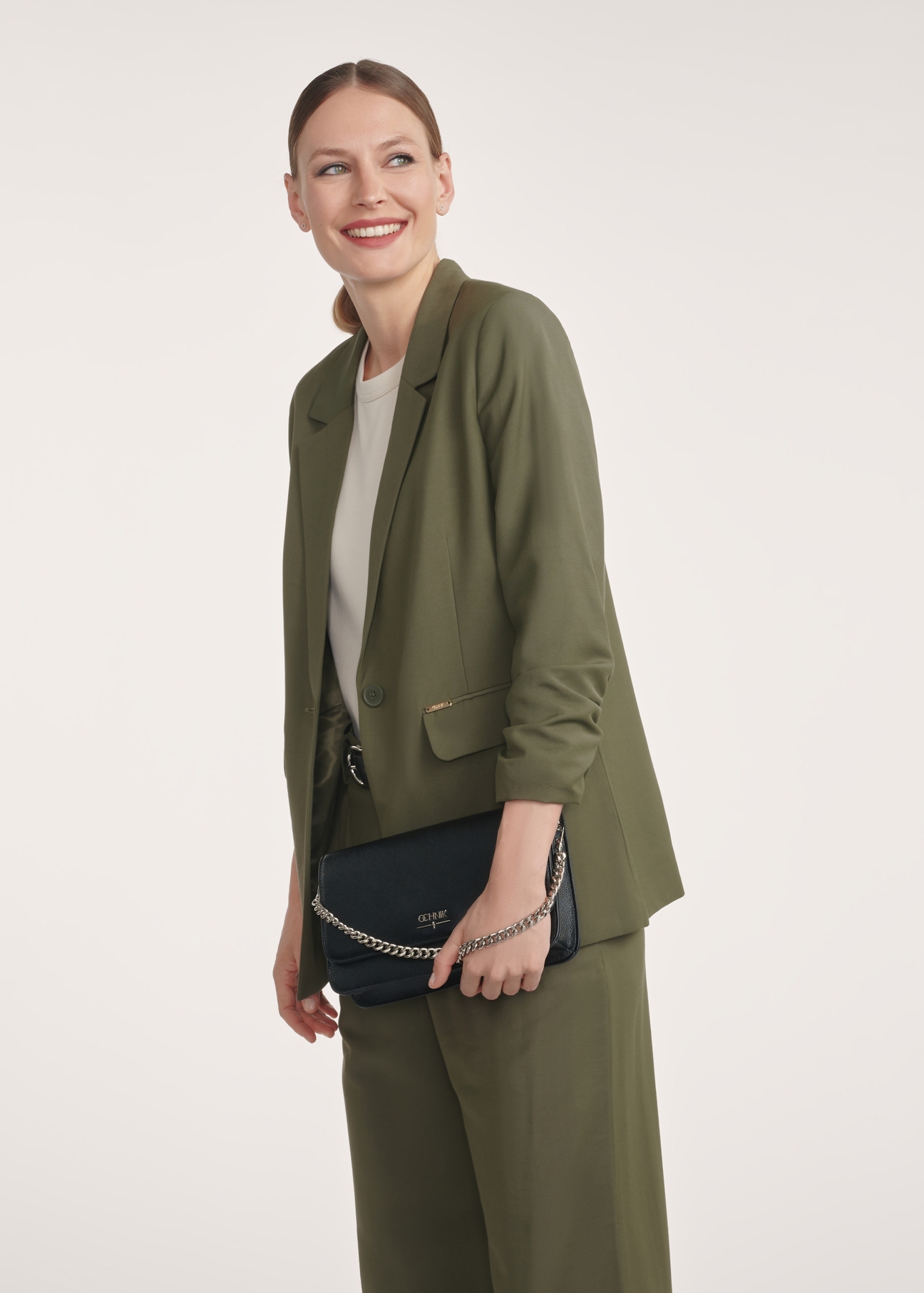 Black women's handbag with chain TOREC-1047-99(Z25), front view of the product on the model, half of the silhouette visible.