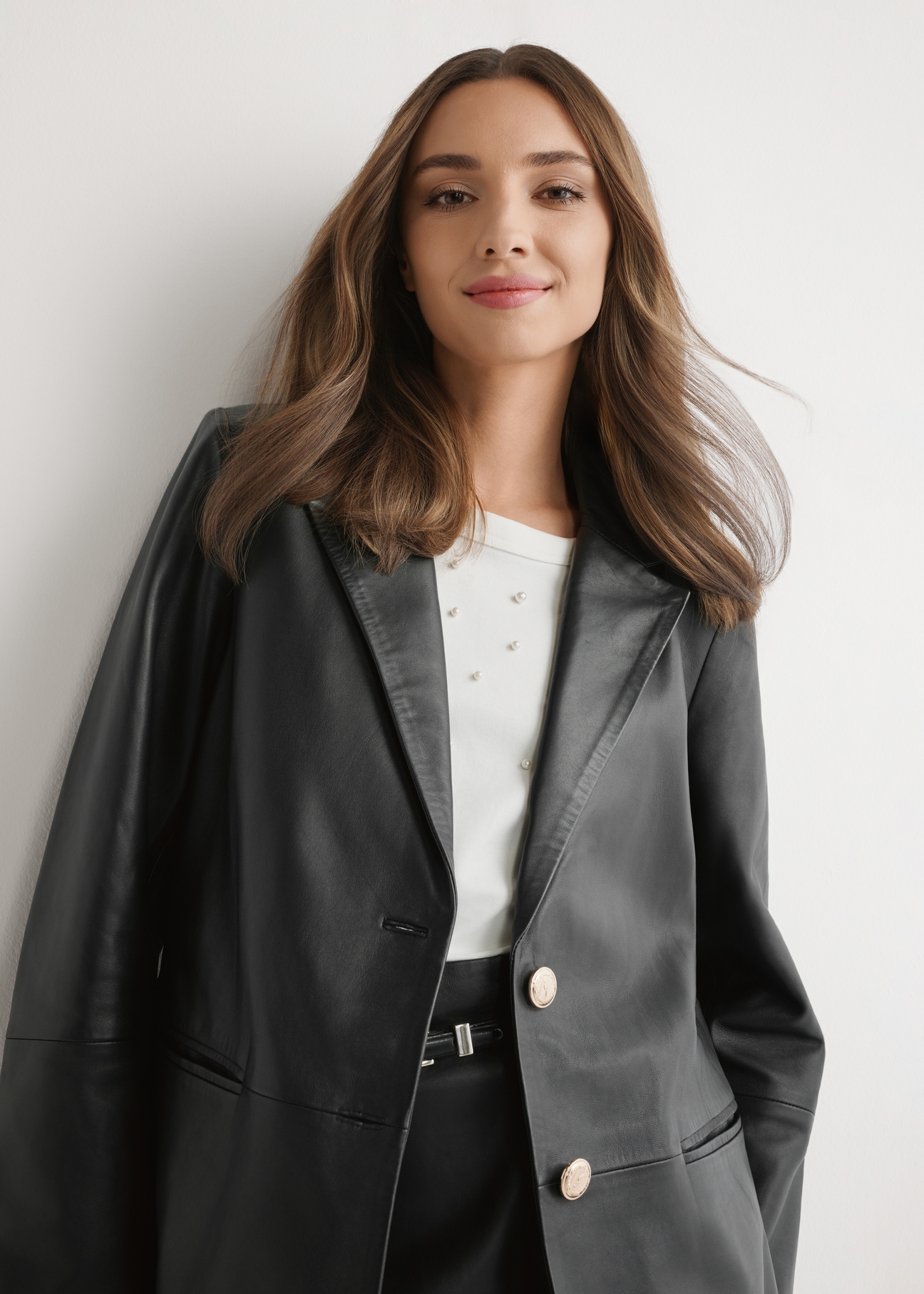 Women's black leather jacket KURDS-0606-99(W26) - front view of the product, on a model, against a light background. Half of the silhouette visible.