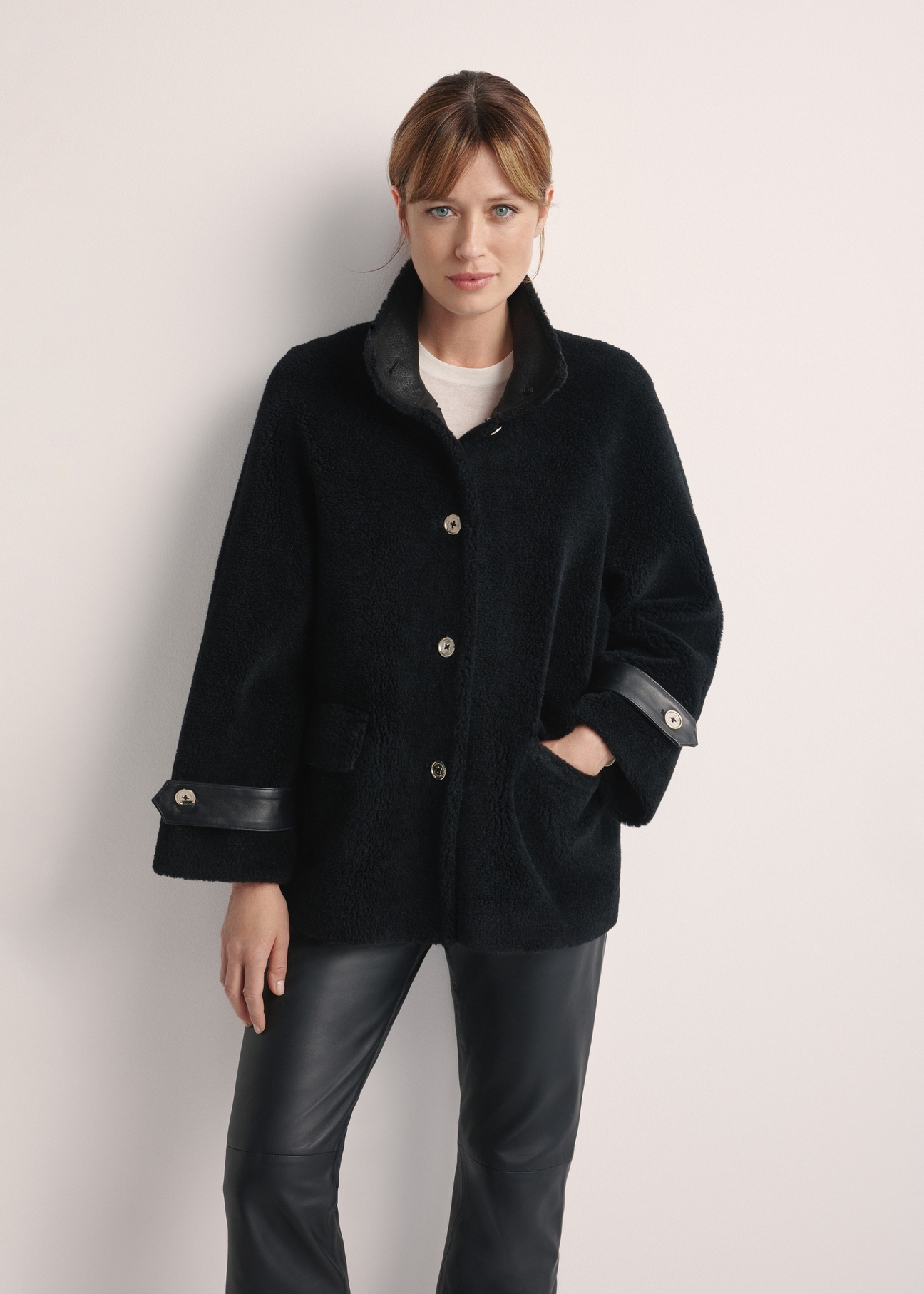 Women's wool fur coat in black FUTDW-0032-99(Z25) - front view of the product on a model on a white background. Half of the silhouette visible.
