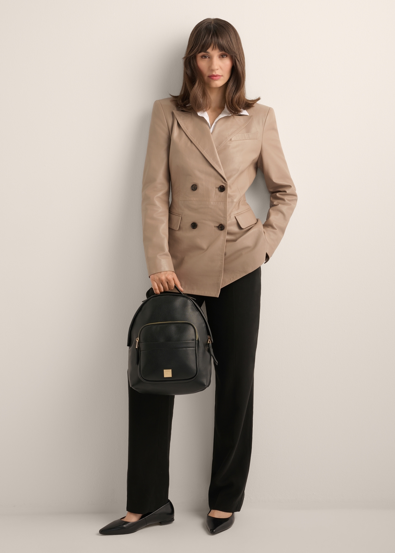 Black women's backpack TOREC-1253-9I(Z26), product view in model's hand. Full body visible.