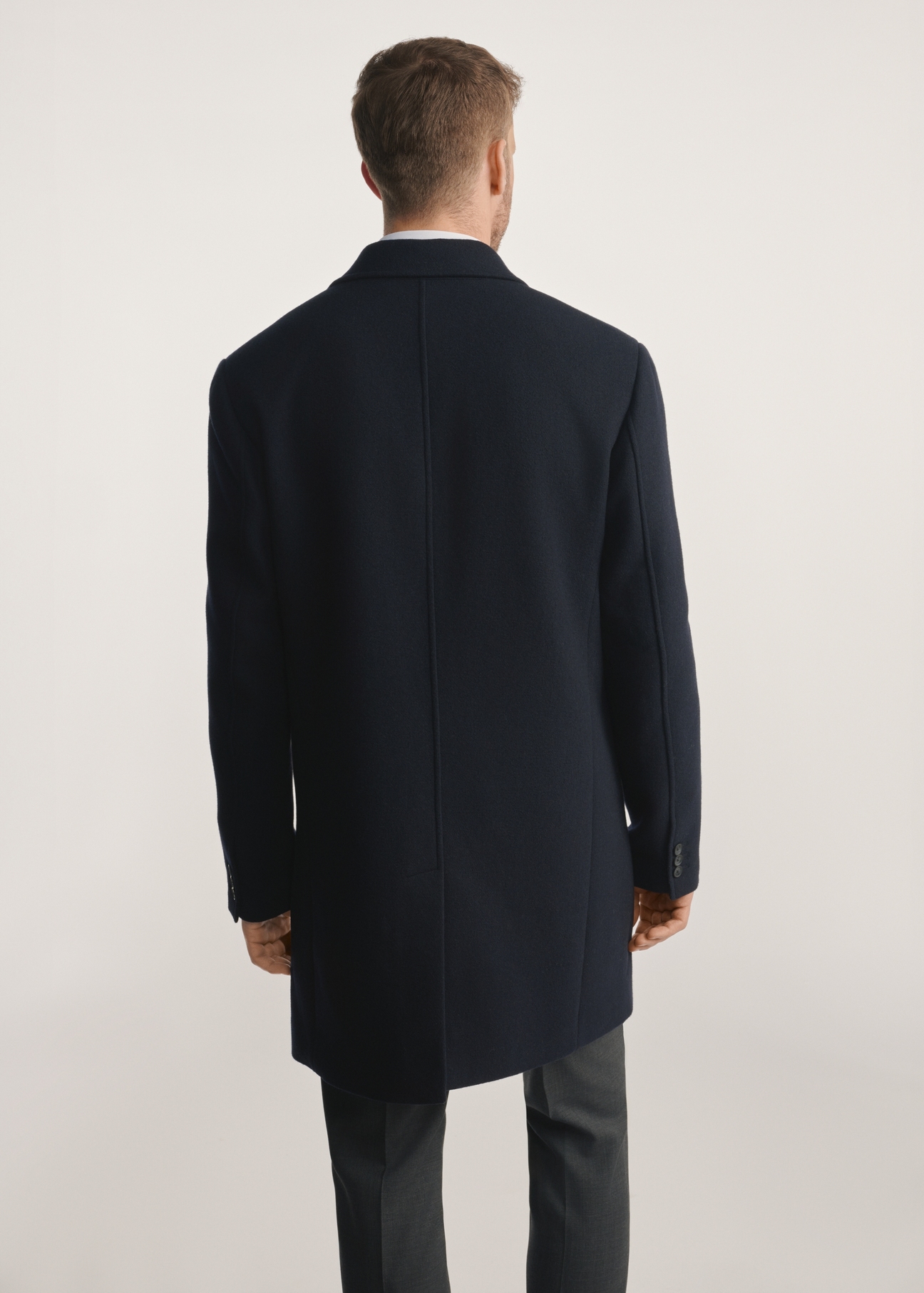 Navy blue men's coat PLAMT-0006-69(Z25), product visible from the back on the model, half of the silhouette visible.