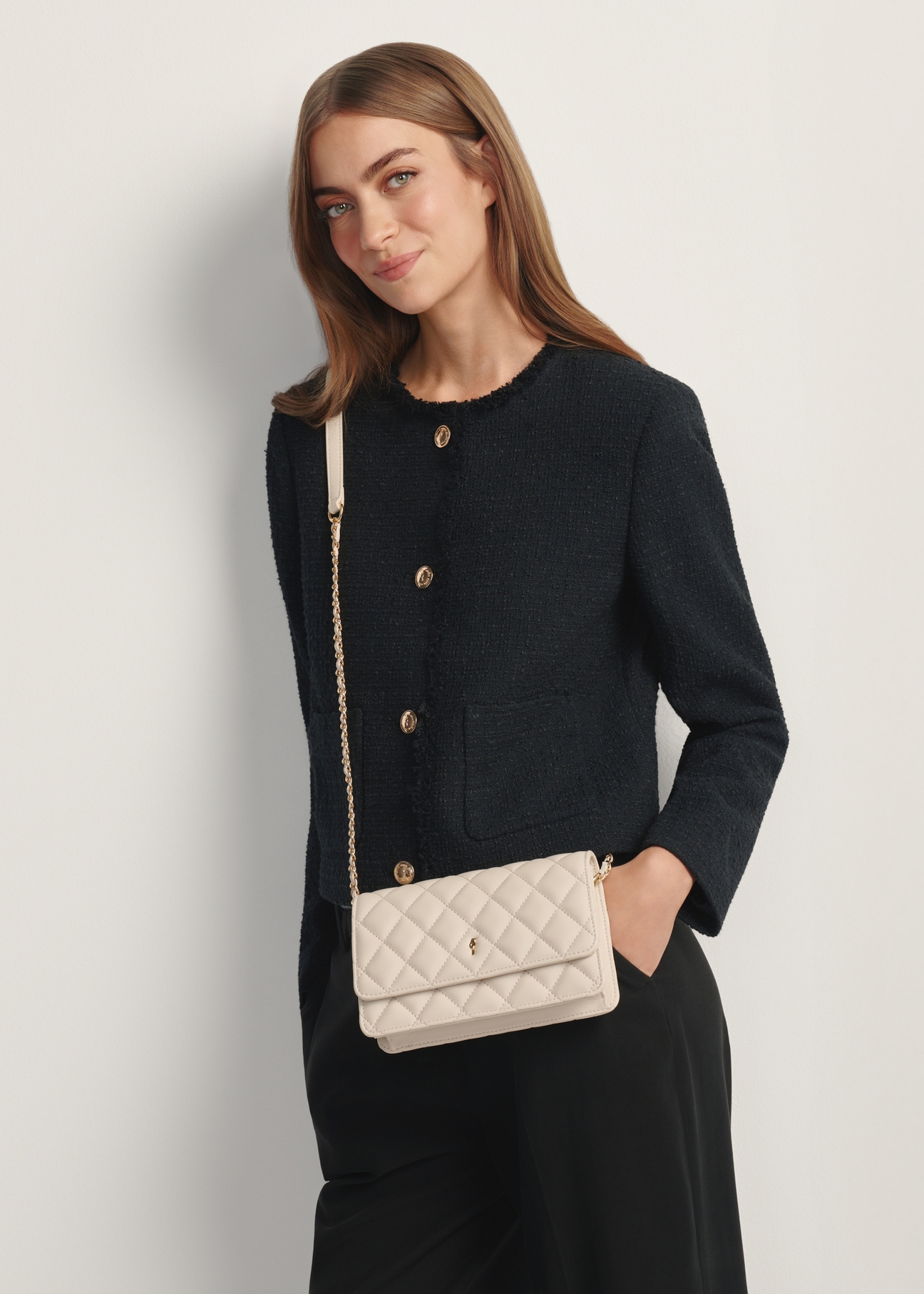 Small quilted women's handbag in cream TOREC-1150-0B(W26) - front view of the product, on a model, against a light background. Half-length silhouette visible.