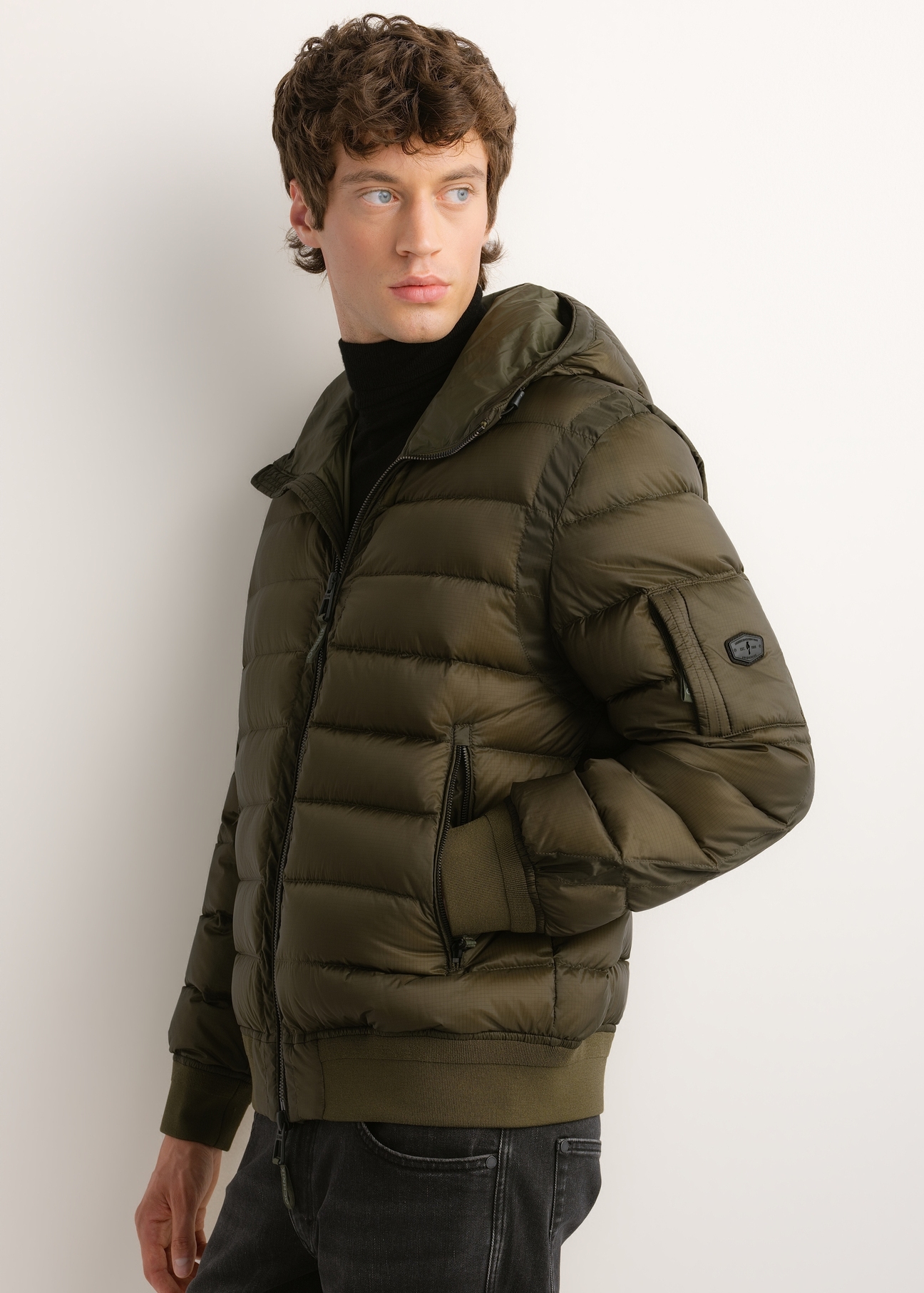 Men's green nylon jacket KURMT-0608-8B(Z26), side view of the product on the model. Half of the silhouette visible.