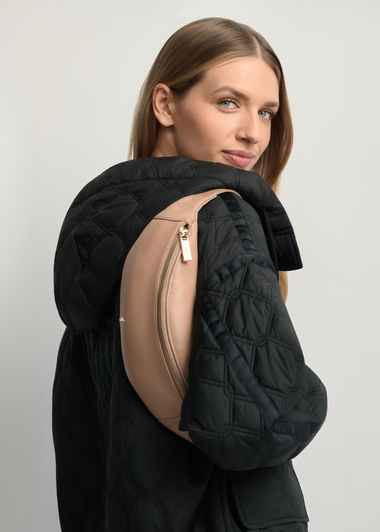 Women's beige leather waist bag TORES-0970F-1B(W26) - side view of the product, on a model, against a light background. Half of the silhouette visible.