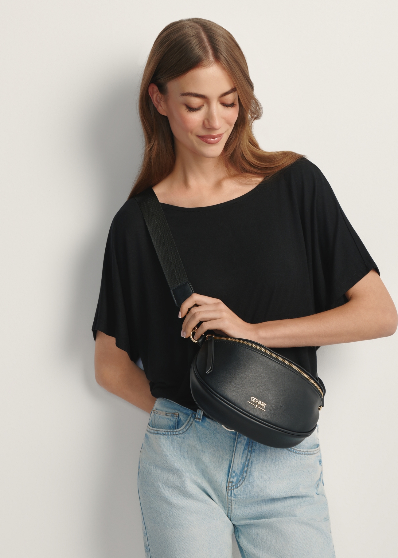Women's black waist bag TOREC-1191-99(W26) - front view of the product, on a model, against a light background. Half of the silhouette visible.