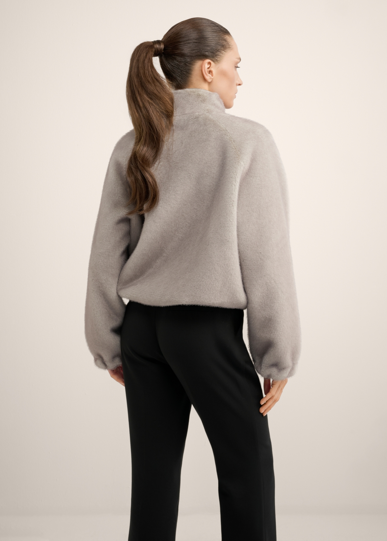 Short gray women's fur coat FUTDP-0083-9B(Z26) product view from the back on the model, half of the silhouette visible.